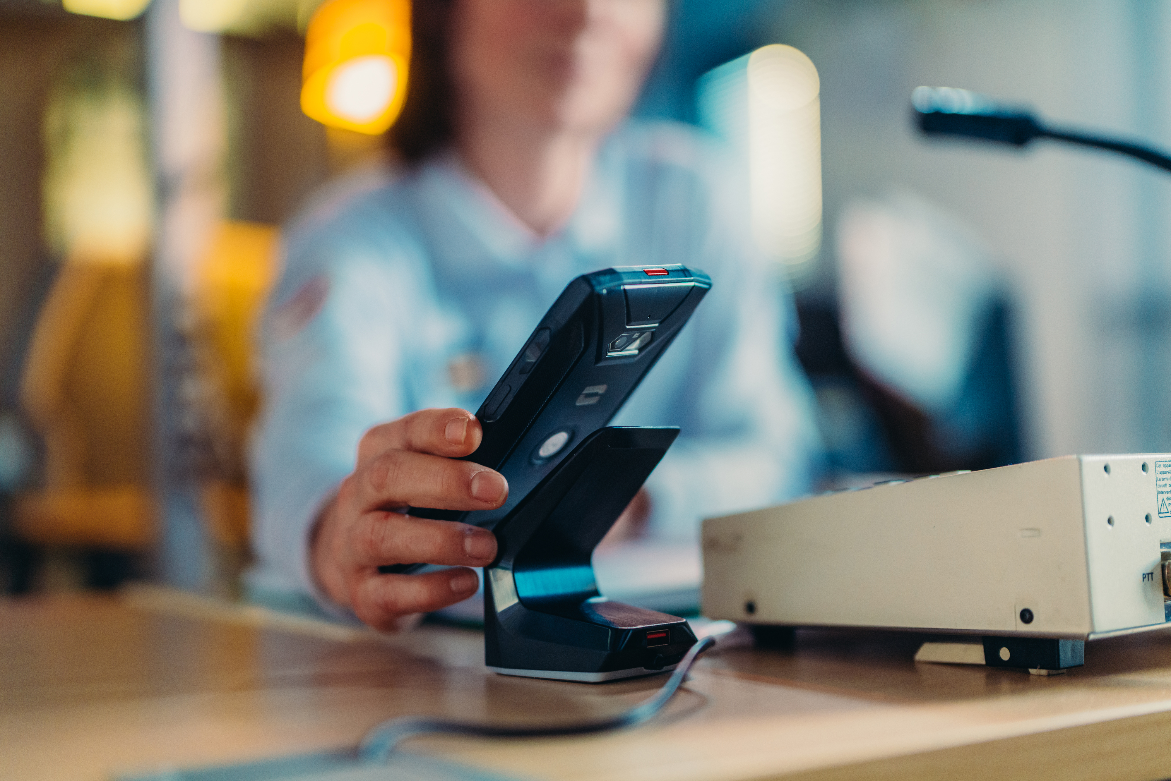 Una persona tiene in mano un telefono su una stazione di ricarica.