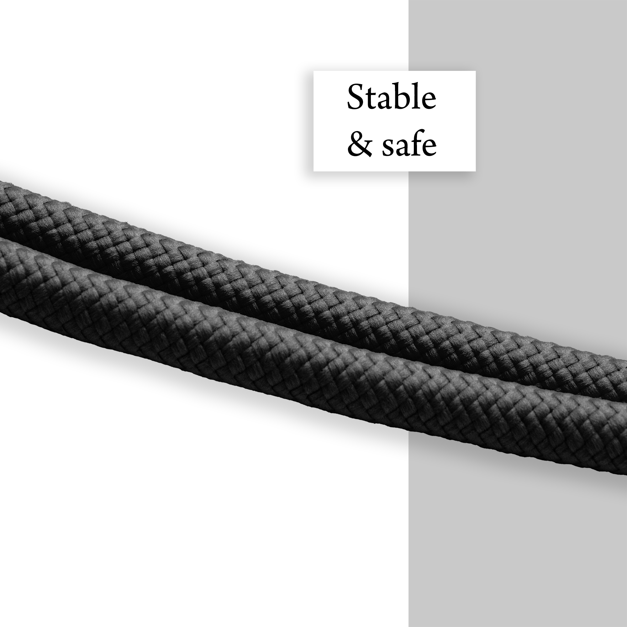 Nahaufnahme eines dunkelgrauen geflochtenen Lanyard-Seils. Weißer und grauer Hintergrund.