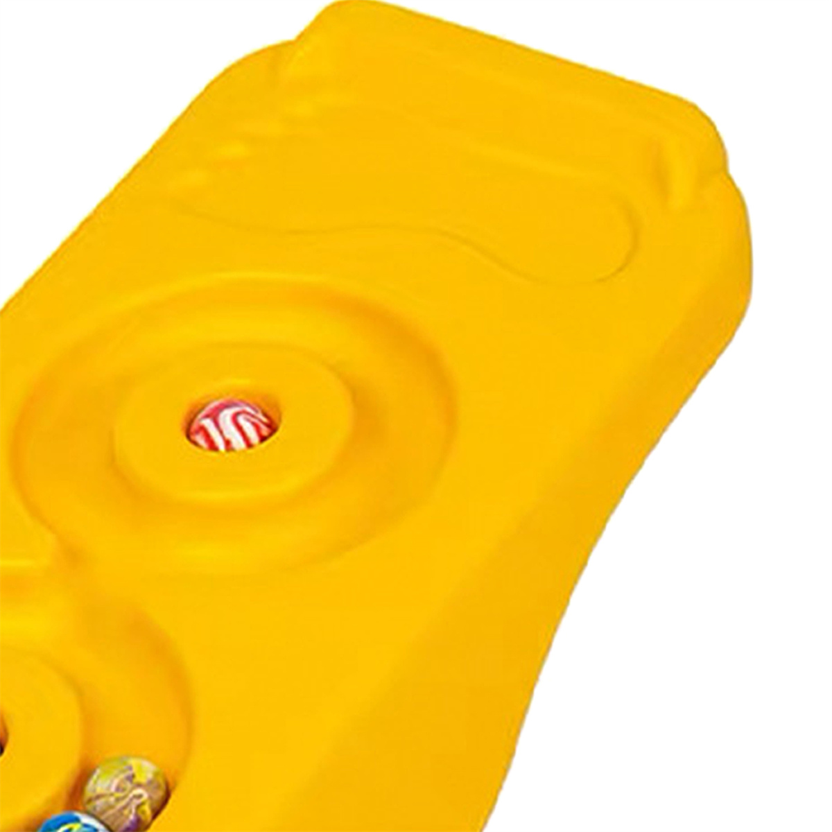 Nahaufnahme eines gelben Kunststoffspielzeugs mit einem eingebetteten roten Knopf.