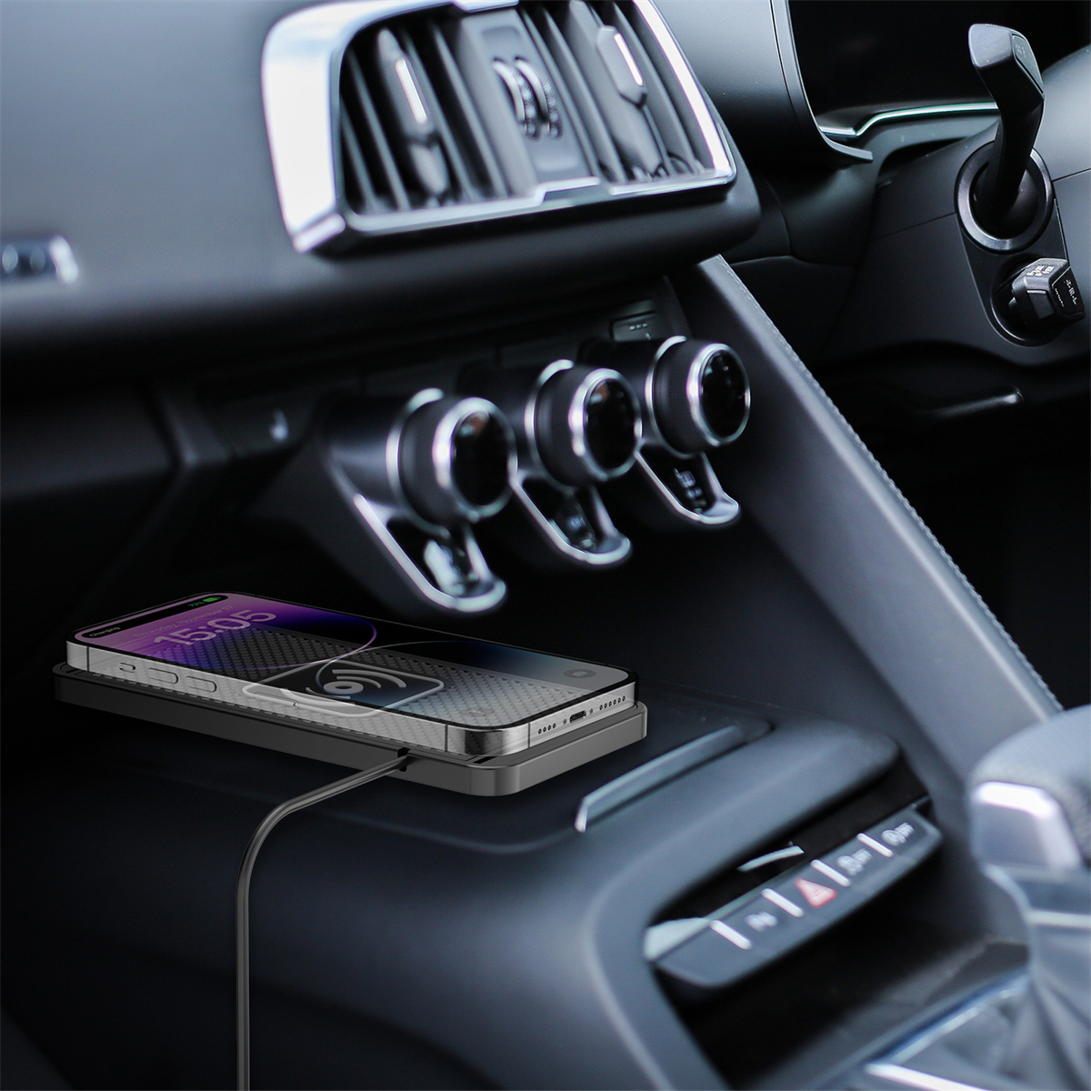 Ein Telefon in einem Auto auf einem Ladepad. Der Innenraum des Autos umfasst Luftschlitze und Bedienelemente.