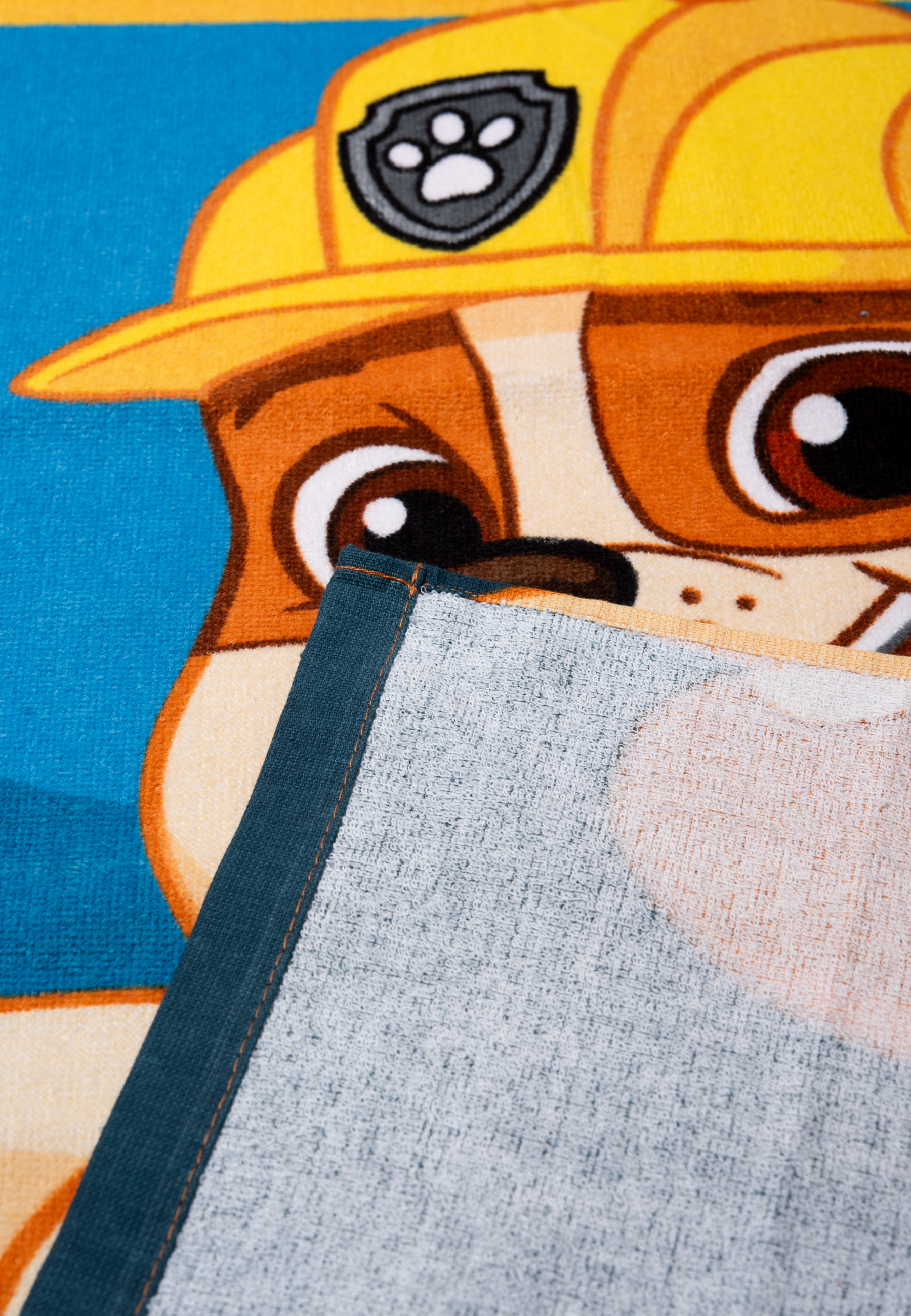 Ein Cartoon-Hund in gelber Arbeitskleidung auf einem blauen Handtuch.