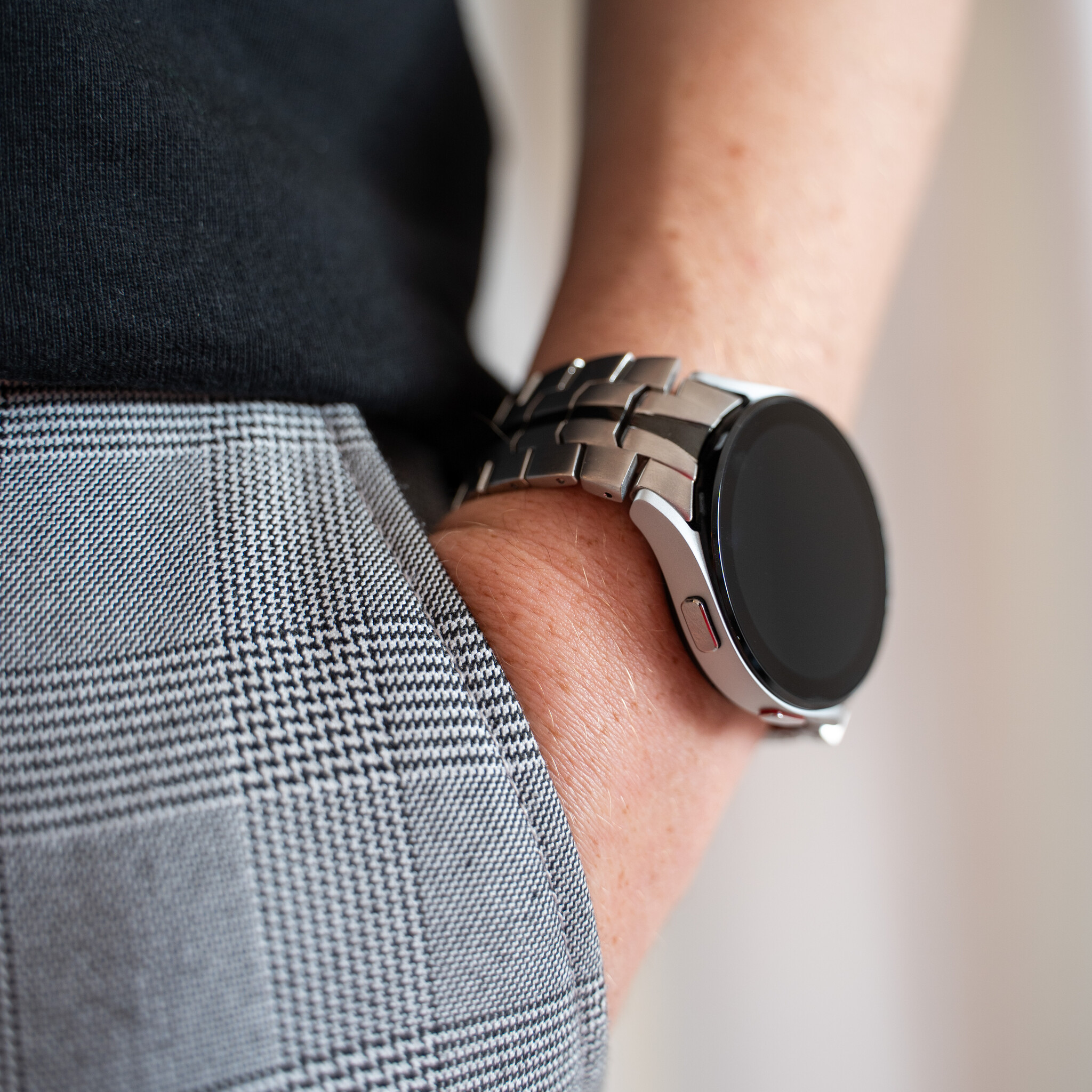 Nahaufnahme des Handgelenks einer Person mit einer silbernen Smartwatch.