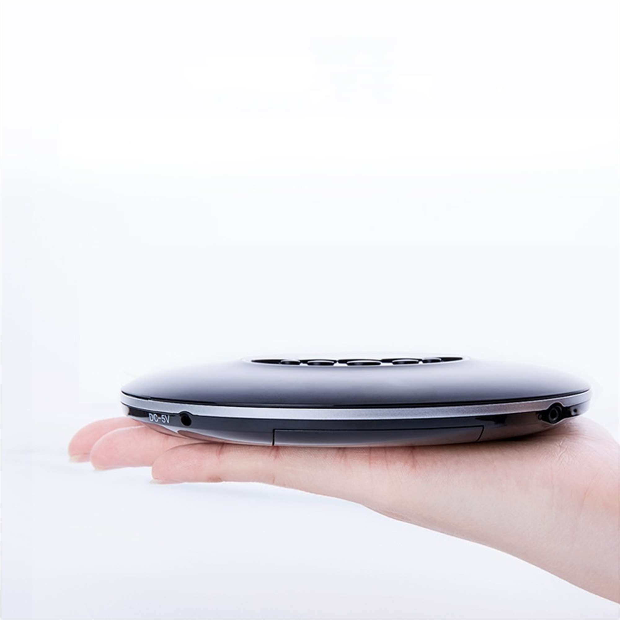 Disc-Player in der Hand einer Person. Der Disc-Player ist schwarz und hat einen Bildschirm. Weißer Hintergrund.