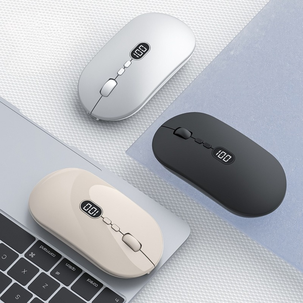Drei kabellose Computer-Mäuse: weiß, beige und schwarz. Jede zeigt einen Batteriestand.