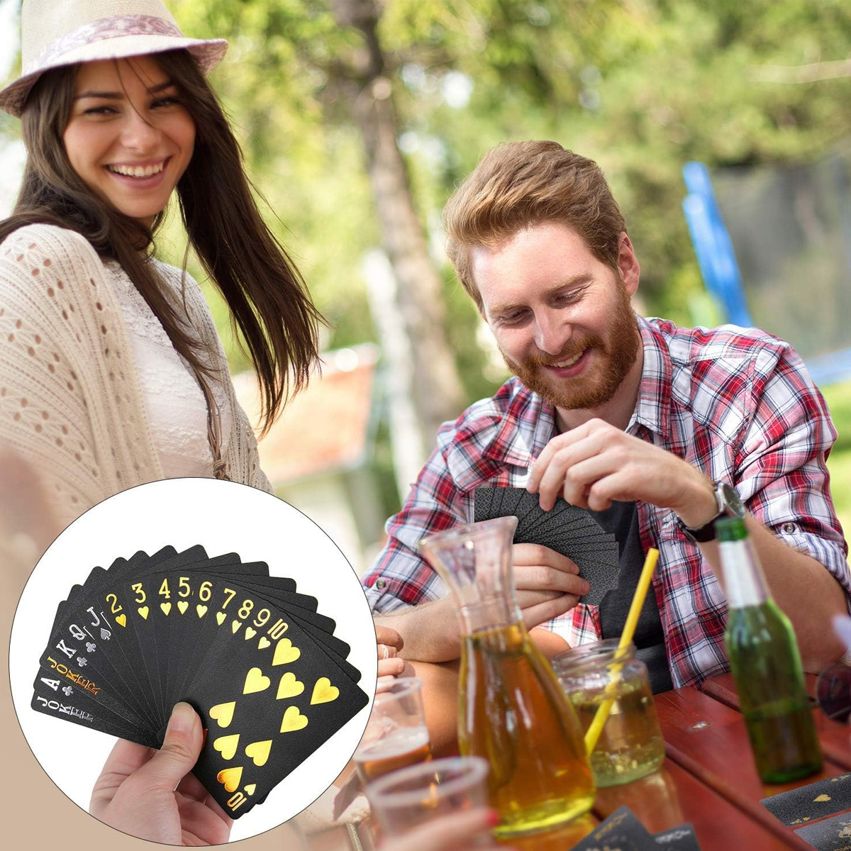Zwei Personen spielen Karten. Eine Hand hält schwarze Karten mit goldenen Anzugsymbolen.