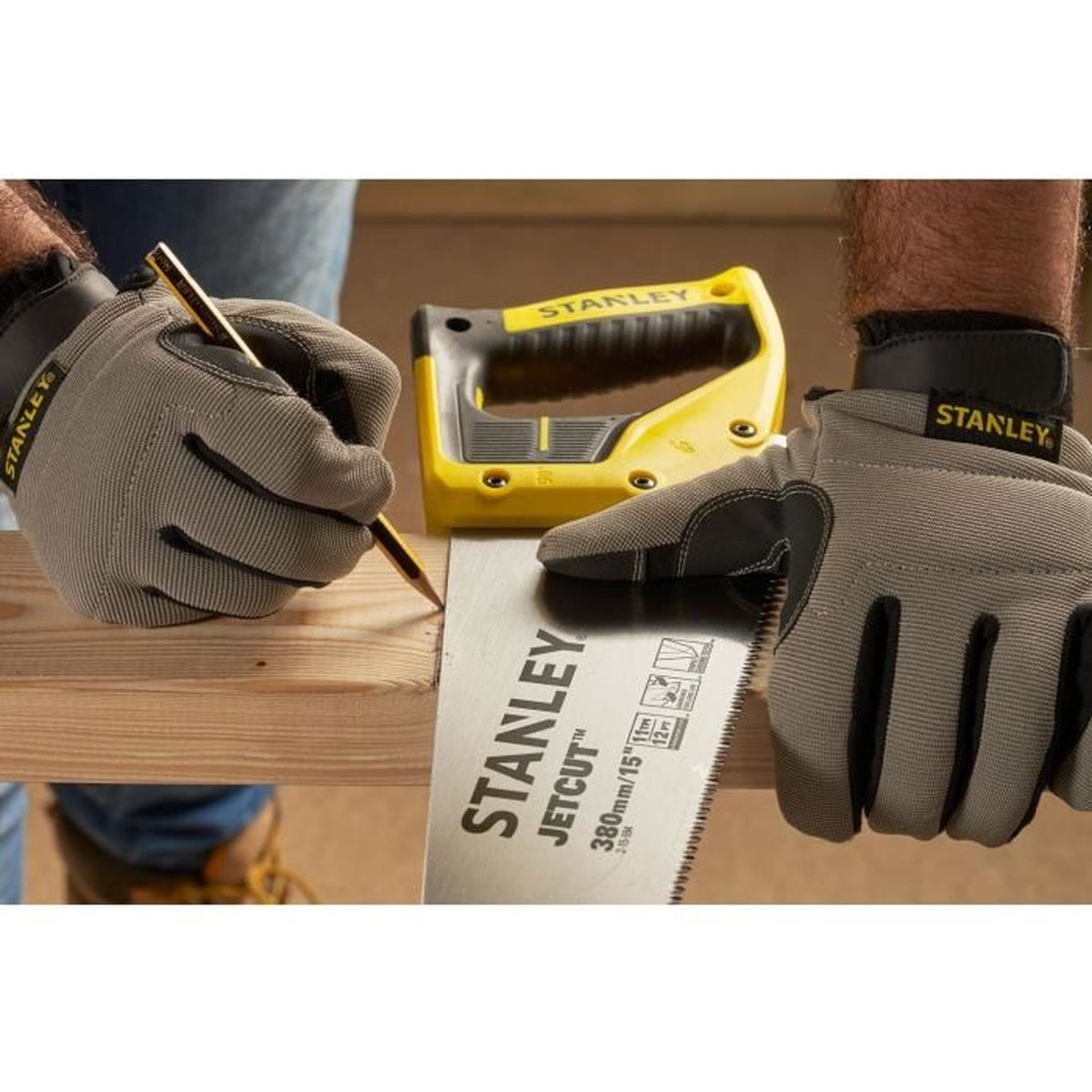 Hände mit Handschuhen arbeiten mit einer Säge und einem Bleistift an einer Holzplanke.