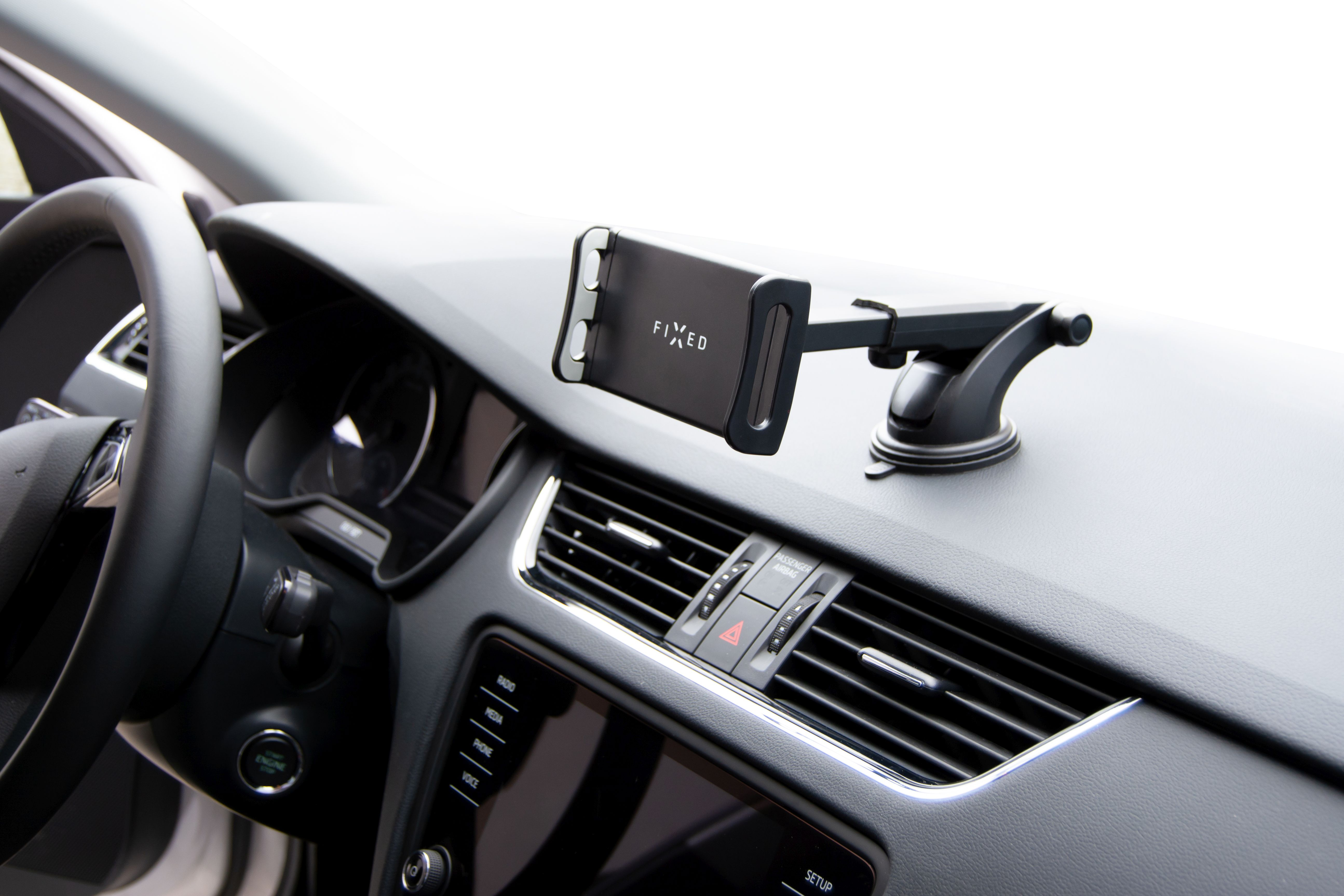 Ein schwarzer Telefonhalter, der auf dem Armaturenbrett eines Autos montiert ist. Der Halter hält ein Telefon.