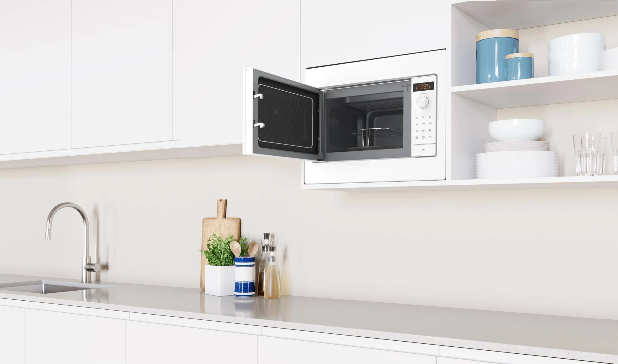 Un horno microondas blanco empotrado con la puerta abierta, en una cocina blanca.