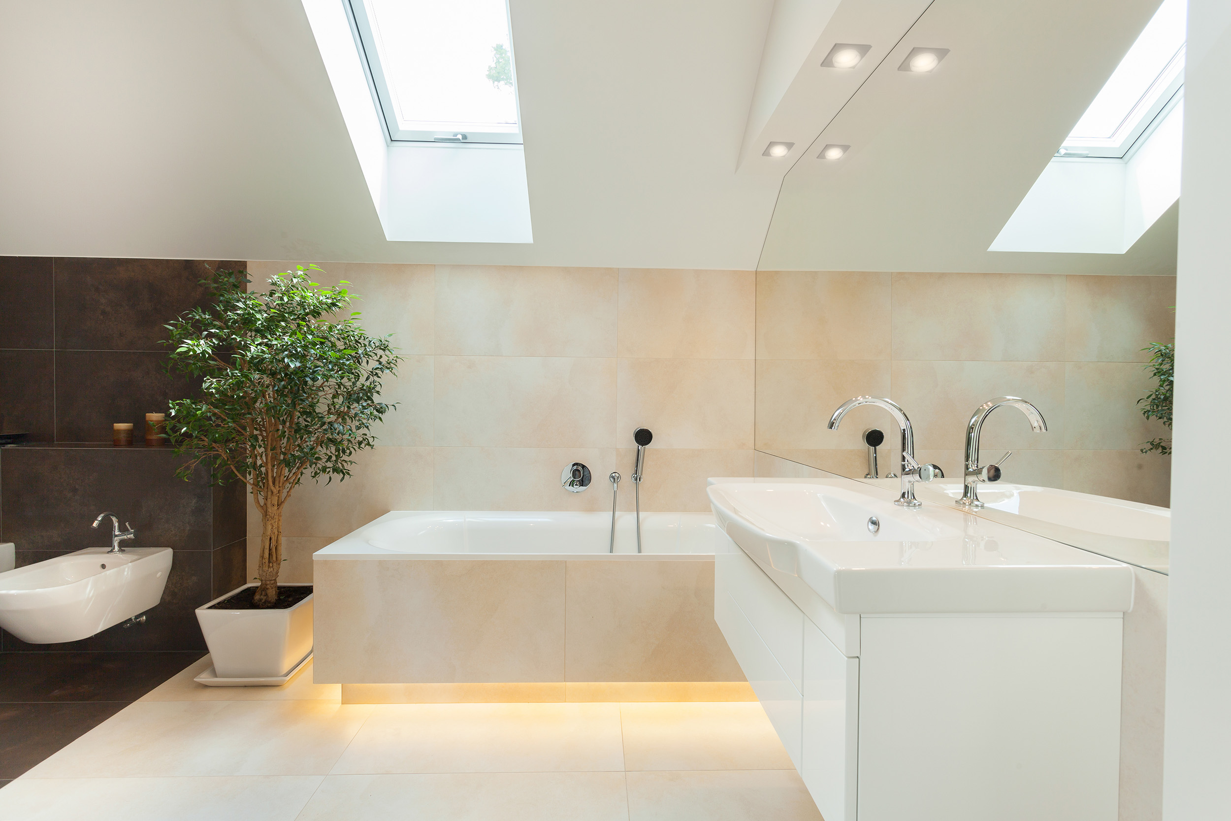Modernes Badezimmer mit Badewanne, Waschbecken und großem Spiegel.