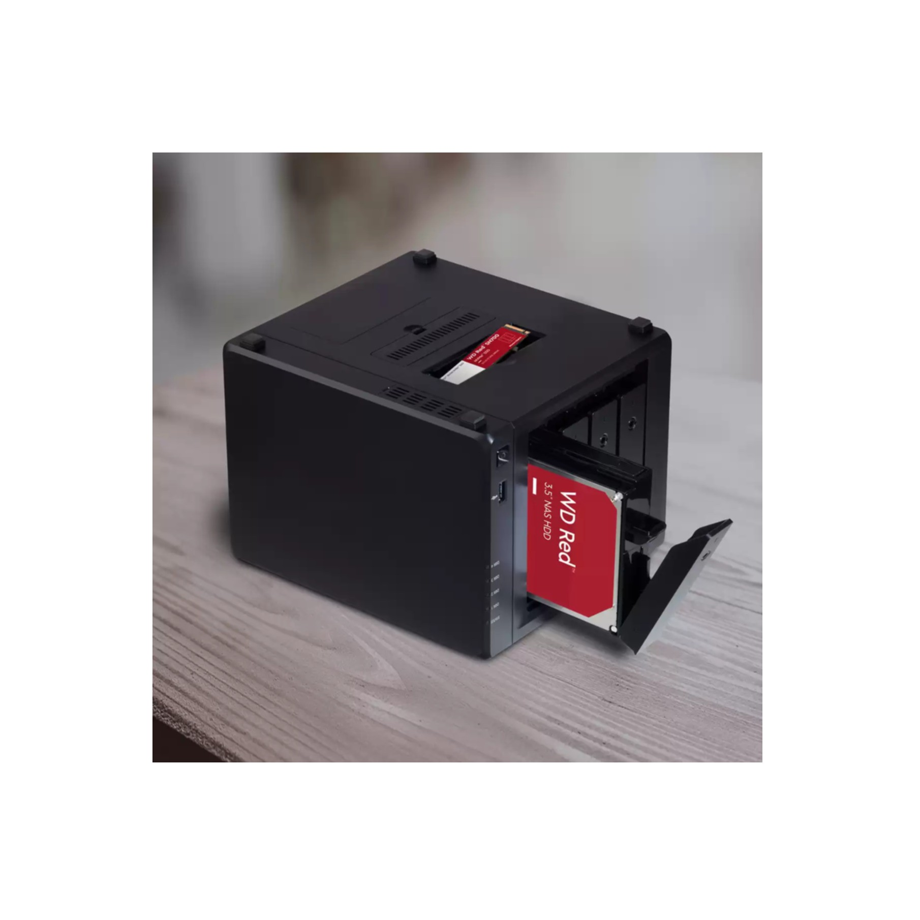 Czarna obudowa dysku twardego, z częściowo włożonym czerwonym dyskiem twardym.