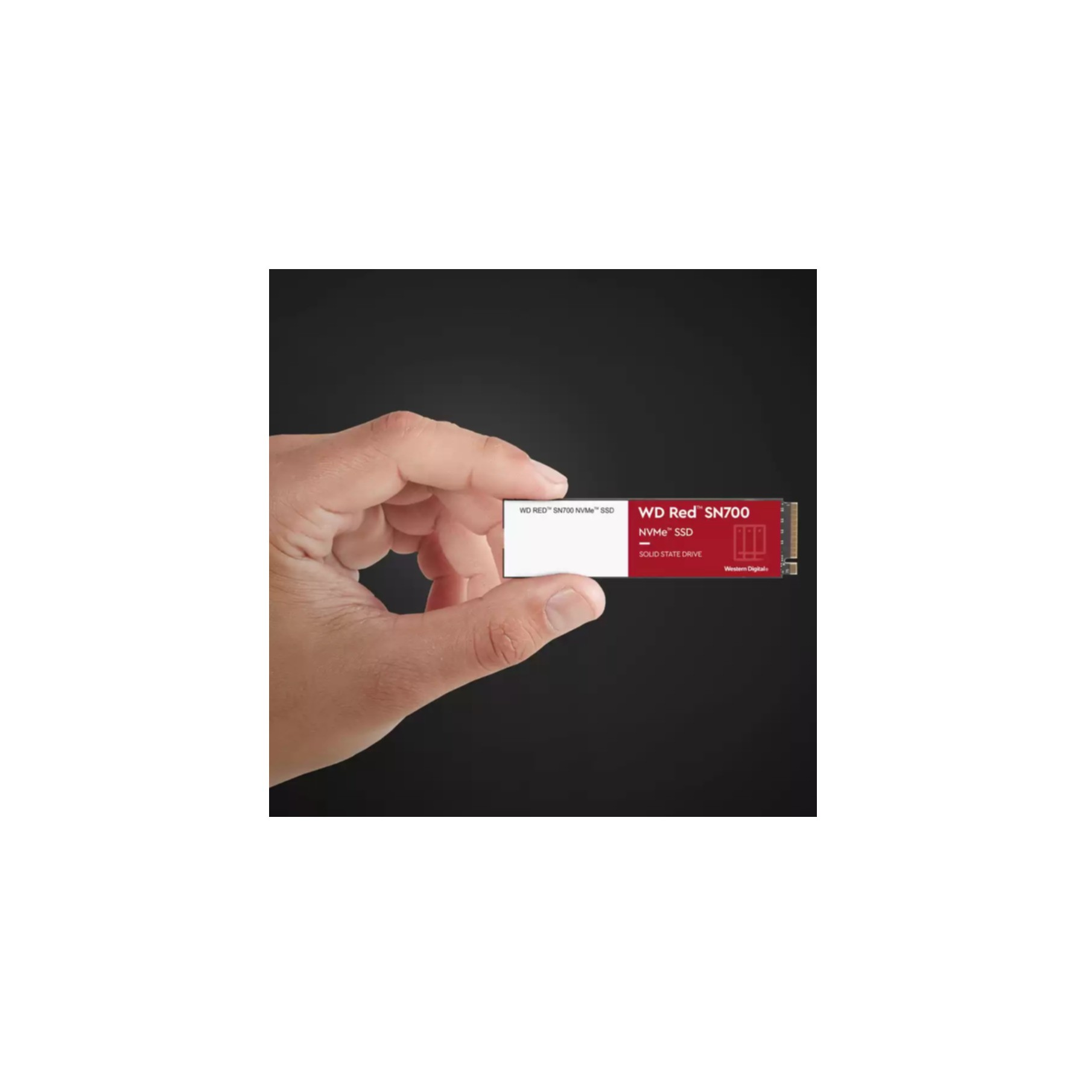 Dłoń trzymająca dysk SSD NVMe WD Red SN700, biała etykieta i czarne tło.