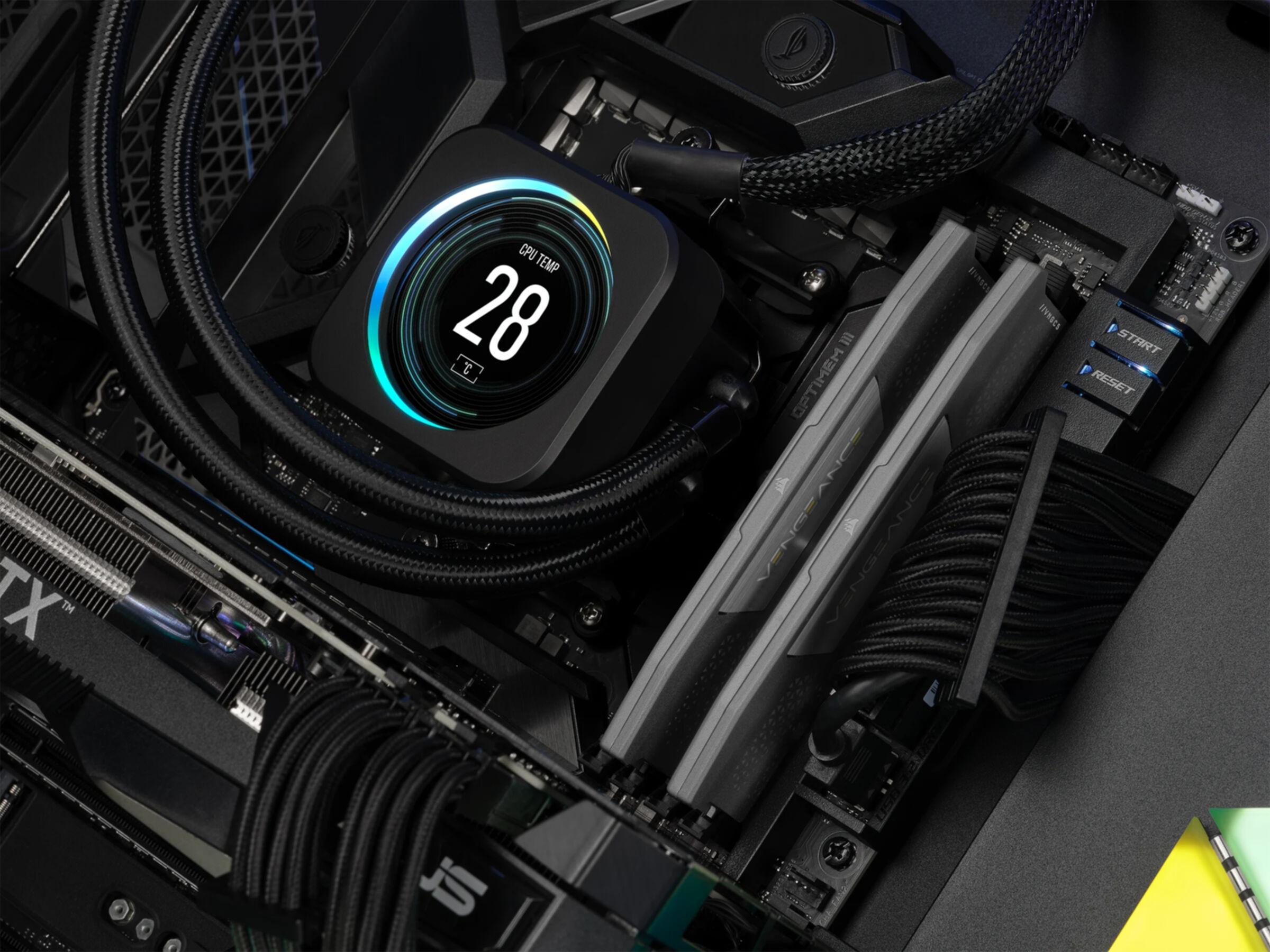 Komponenty PC: chłodnica CPU z wyświetlaczem cyfrowym, kości RAM i płyta główna.