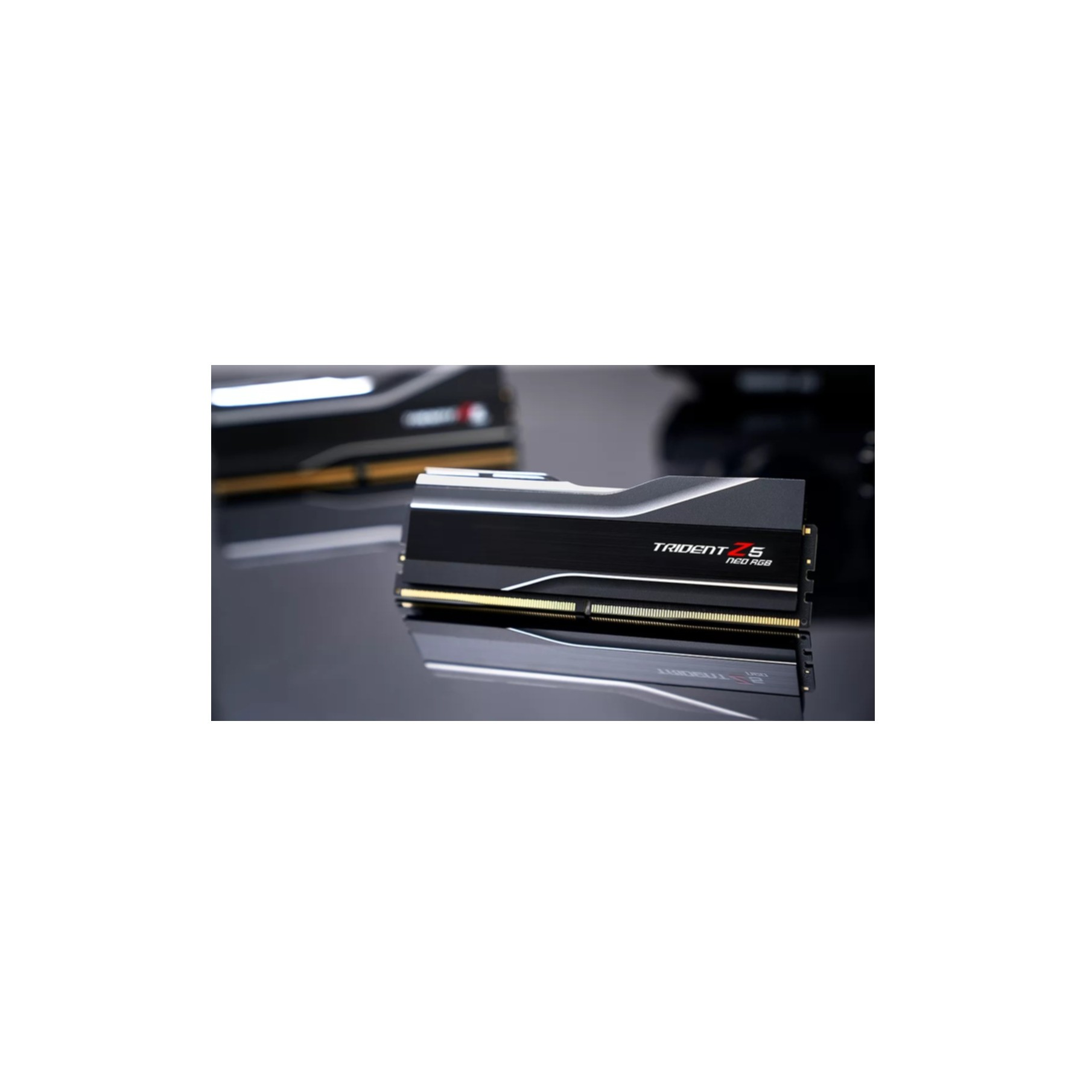 Czarne i srebrne kości RAM ze złotymi akcentami, na odblaskowej powierzchni.
