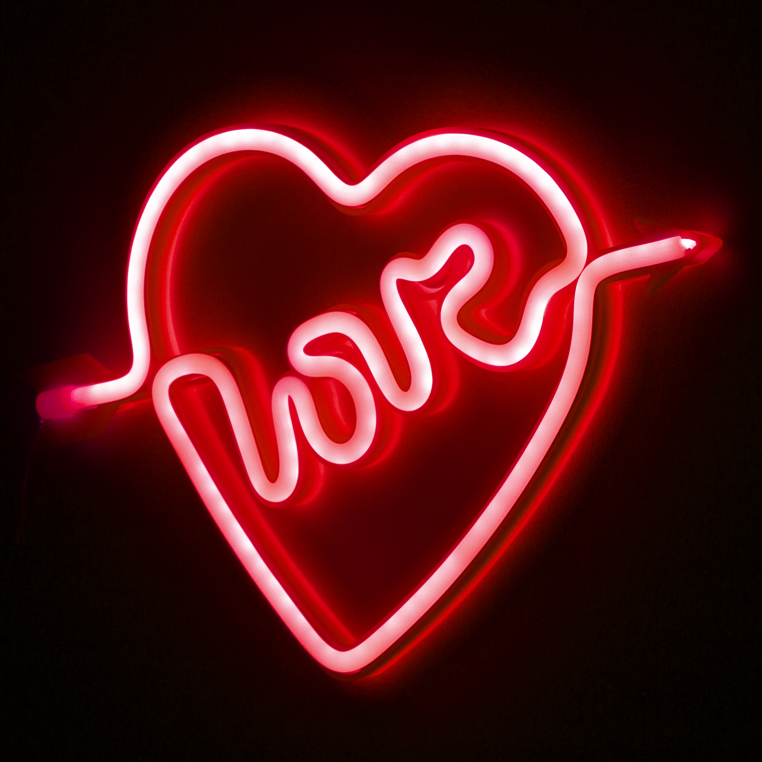 Un letrero de neón rojo en forma de corazón con la palabra 'love'.