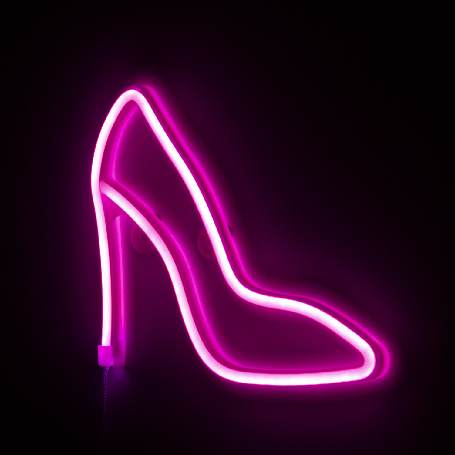 Zapato de tacón de neón rosa sobre fondo negro, brillando intensamente.
