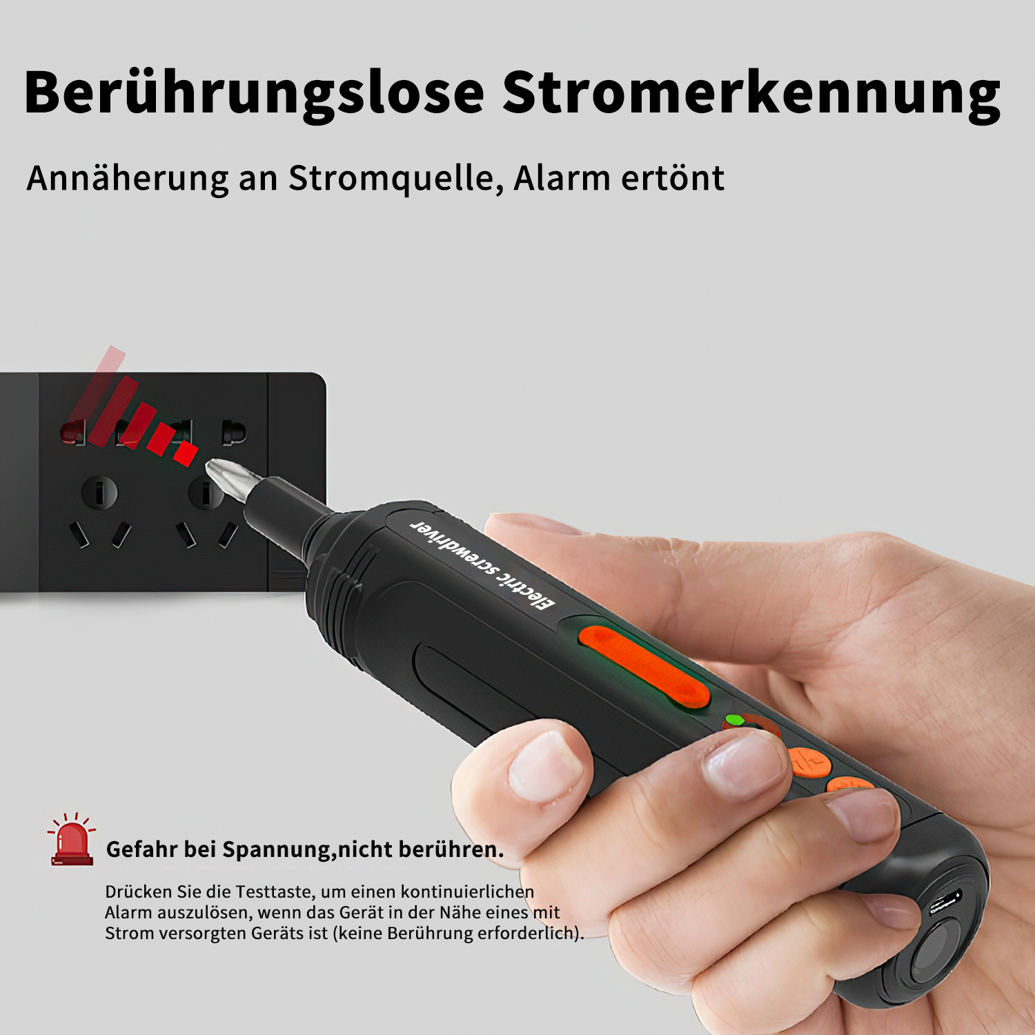 Eine Hand hält einen schwarzen und orangefarbenen Spannungstester in der Nähe einer Steckdose.