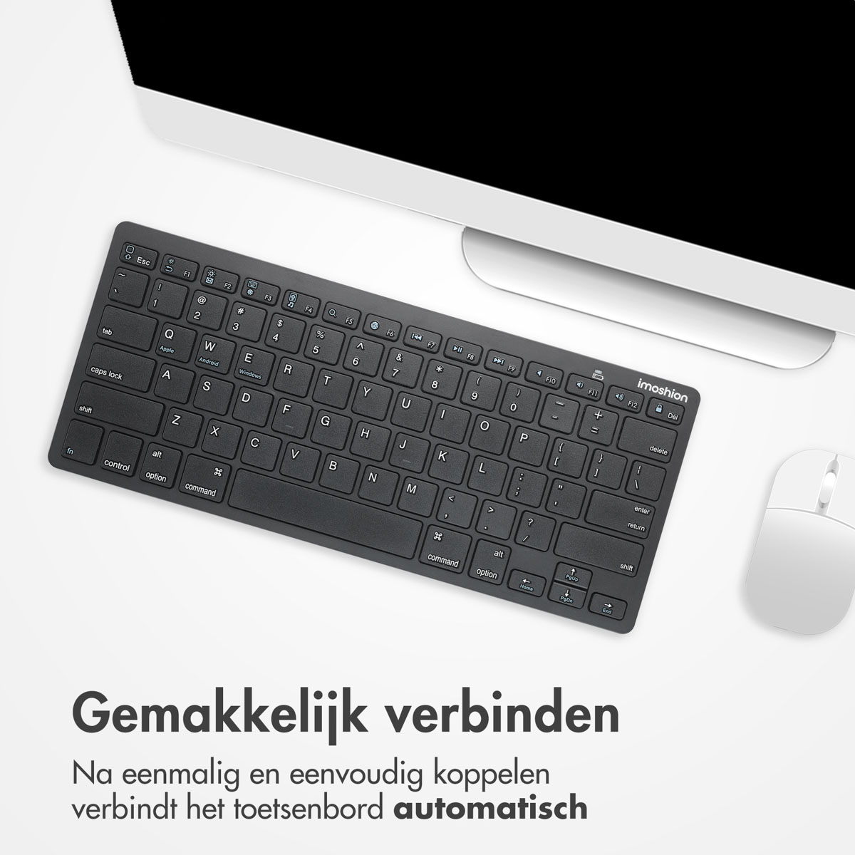 Zwart toetsenbord en witte muis op een bureau. Een computermonitor op de achtergrond.