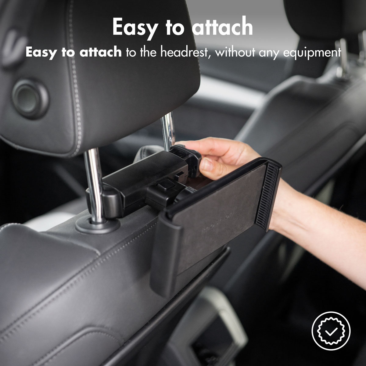 Black tablet holder attached to a car headrest. A hand is attaching the tablet to the mount. 