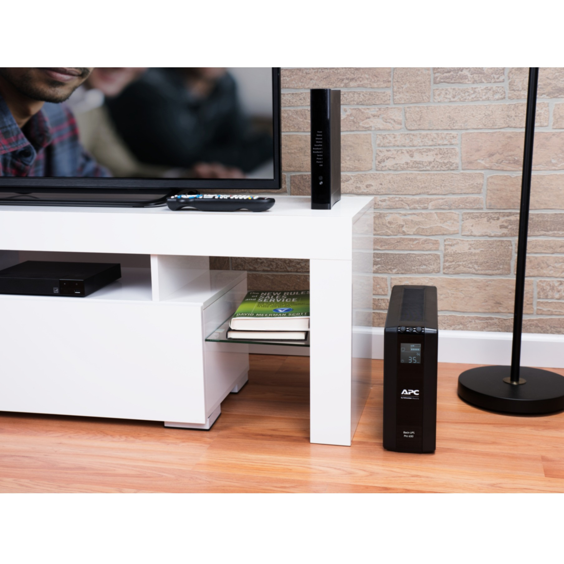 Mobile bianco con TV, libri e UPS.