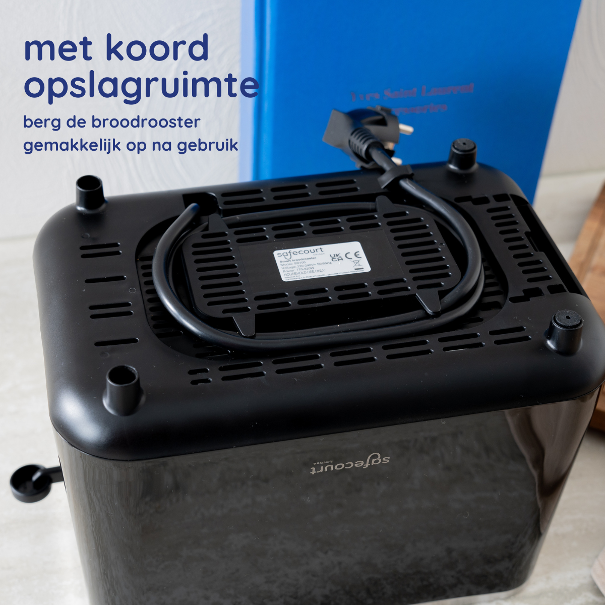 Onderkant van een zwarte broodrooster met snoeropslag en een stekker.