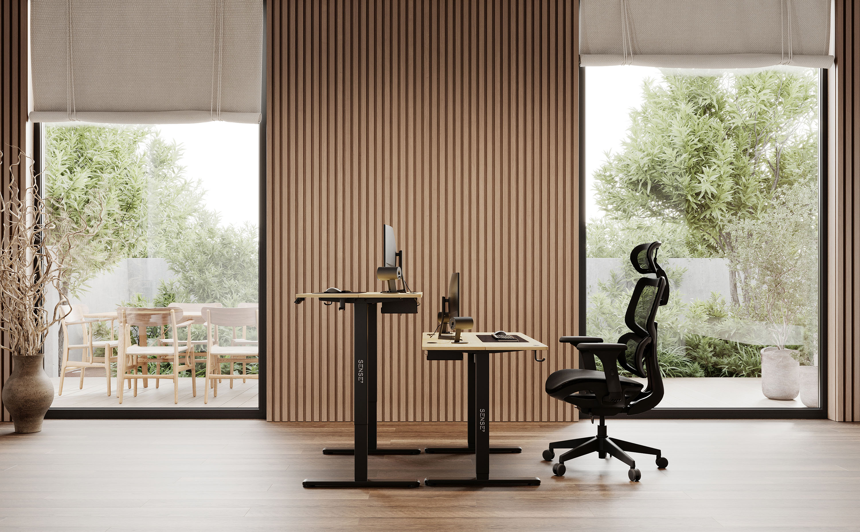 Modernes Büro mit zwei Schreibtischen, einem Stuhl und großen Fenstern mit Blick auf den Garten.