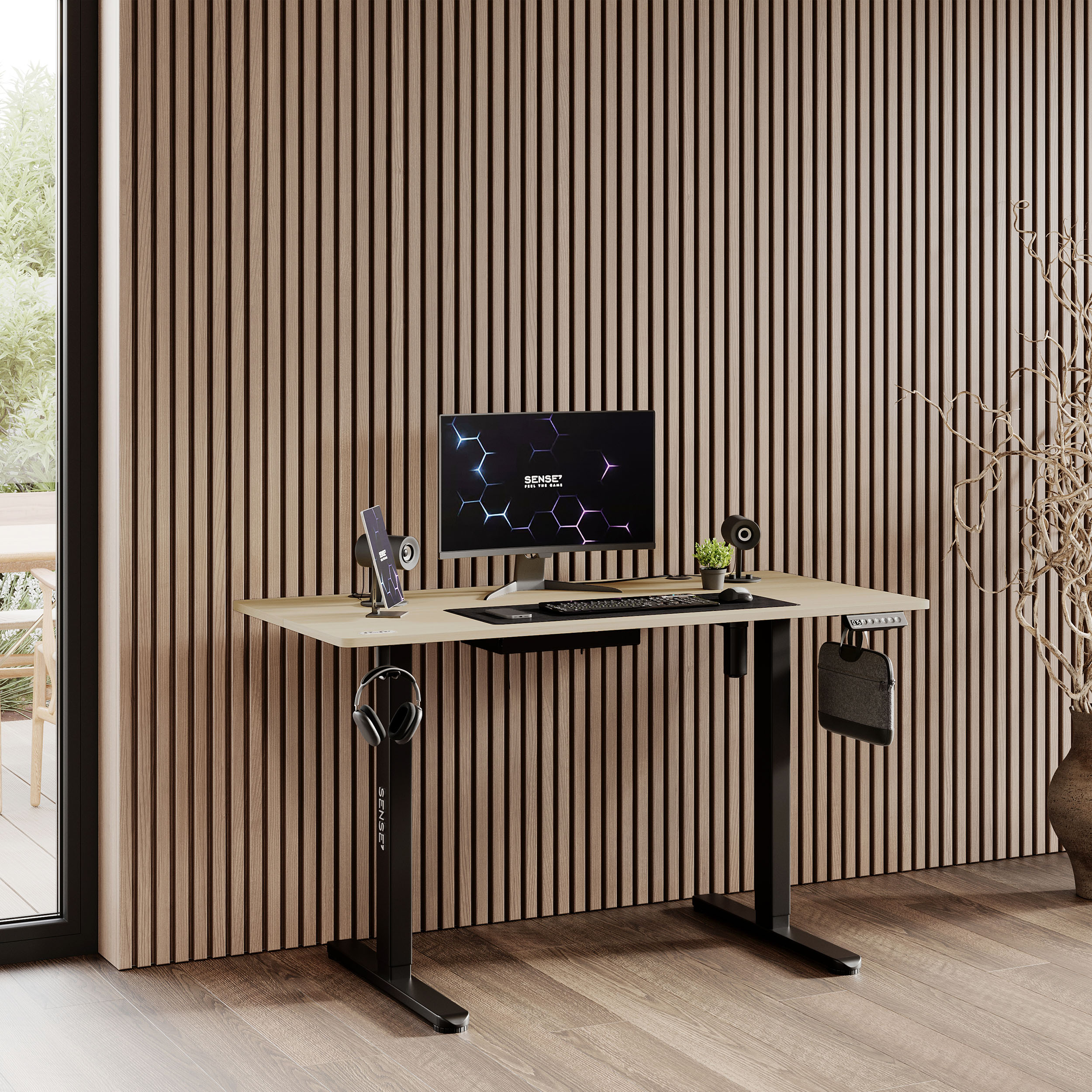 Una scrivania con un computer, una lampada, delle cuffie e un supporto per telefono. Pannelli di legno sulla parete.