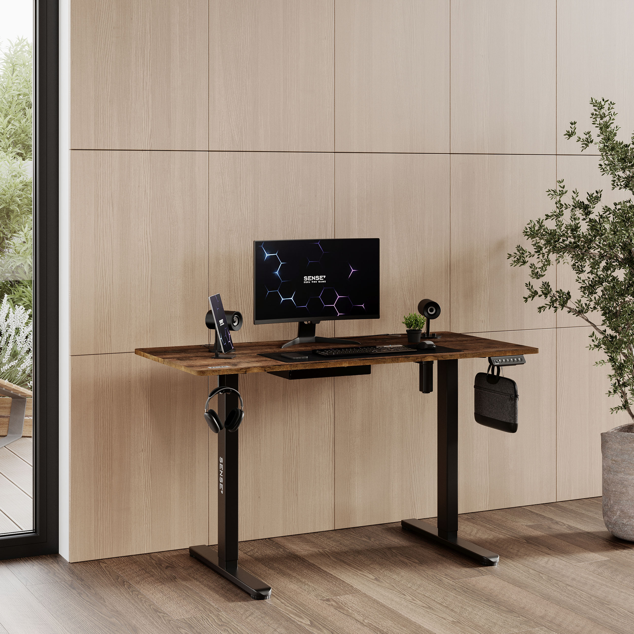 Una scrivania moderna con una configurazione computer, una pianta e altri accessori.