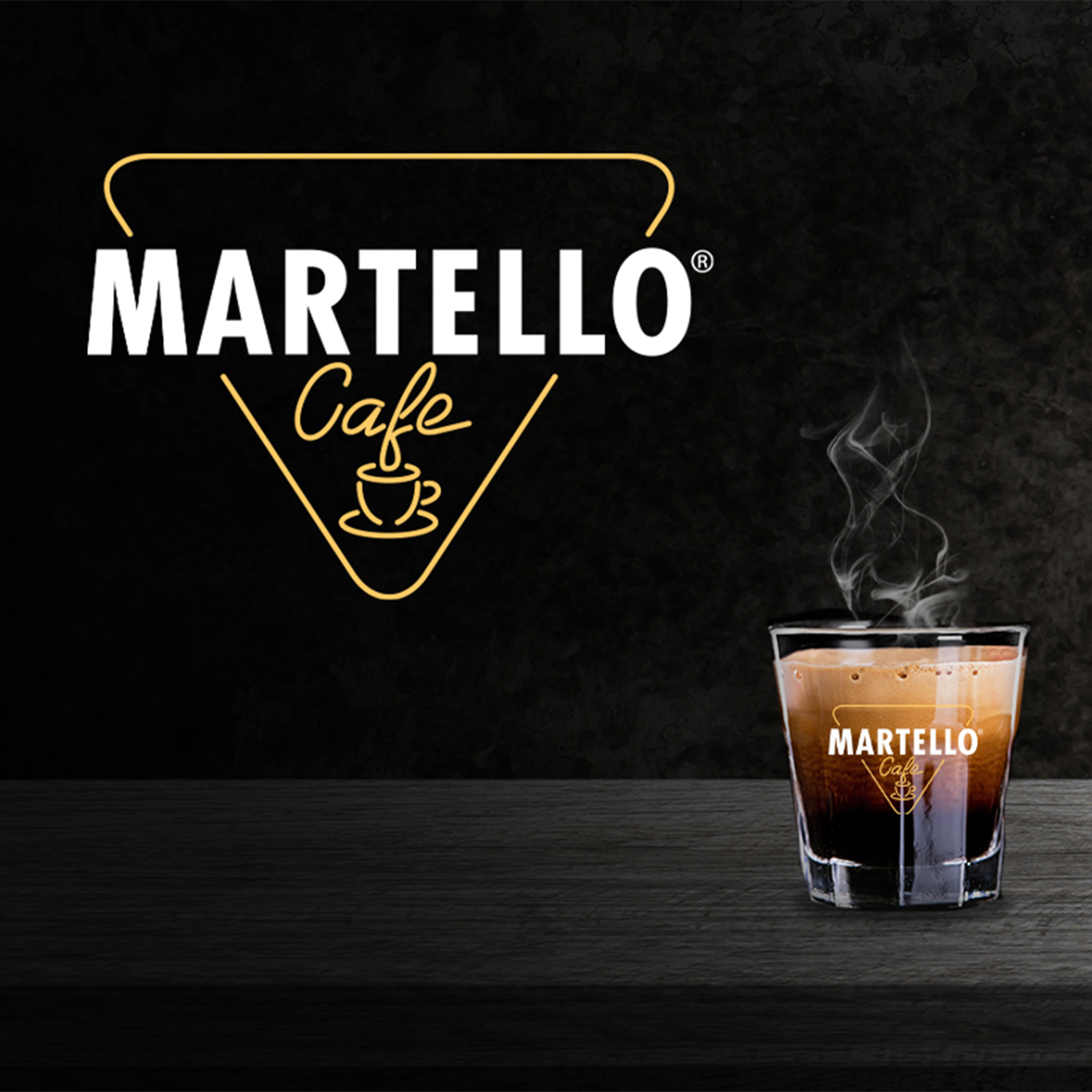 Martello Cafe Kaffee im Glas, mit Logo und Dampf. Schwarzer Hintergrund. Dunkle Holzoberfläche.