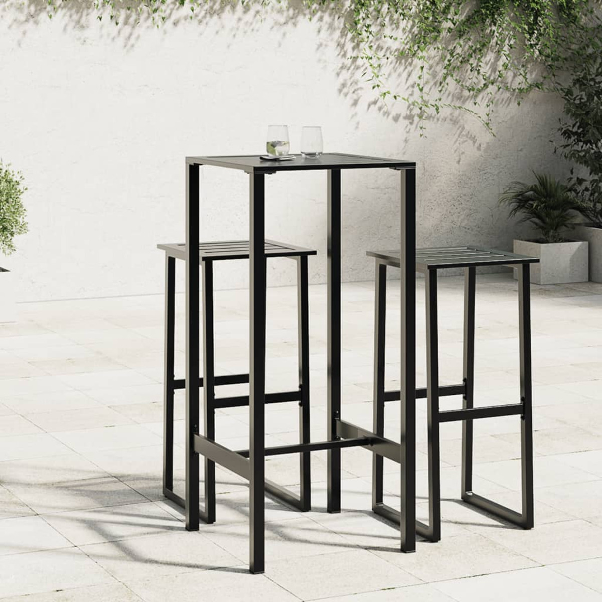 Schwarzes Outdoor-Bar-Set. Quadratischer Tisch und zwei Barhocker. Auf Steinterrasse, mit weißer Wand im Hintergrund.