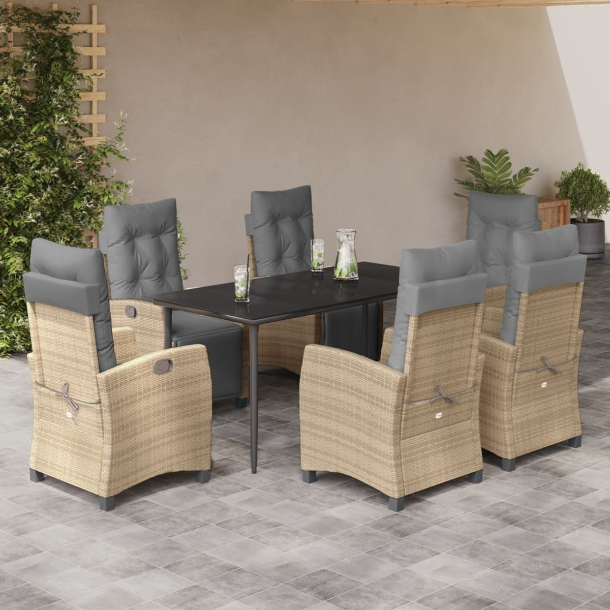 Set da pranzo all'aperto con tavolo nero e sedie in rattan con cuscini grigi. L'ambientazione è su un patio.