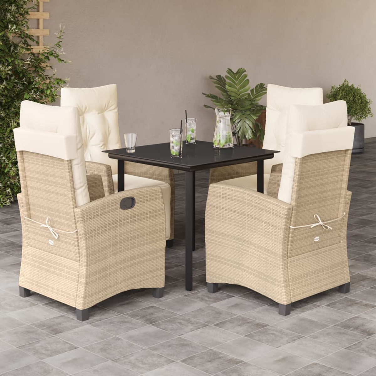 Set da pranzo all'aperto con sedie imbottite beige, tavolo nero e bicchieri con bevande. Pavimento in cemento.