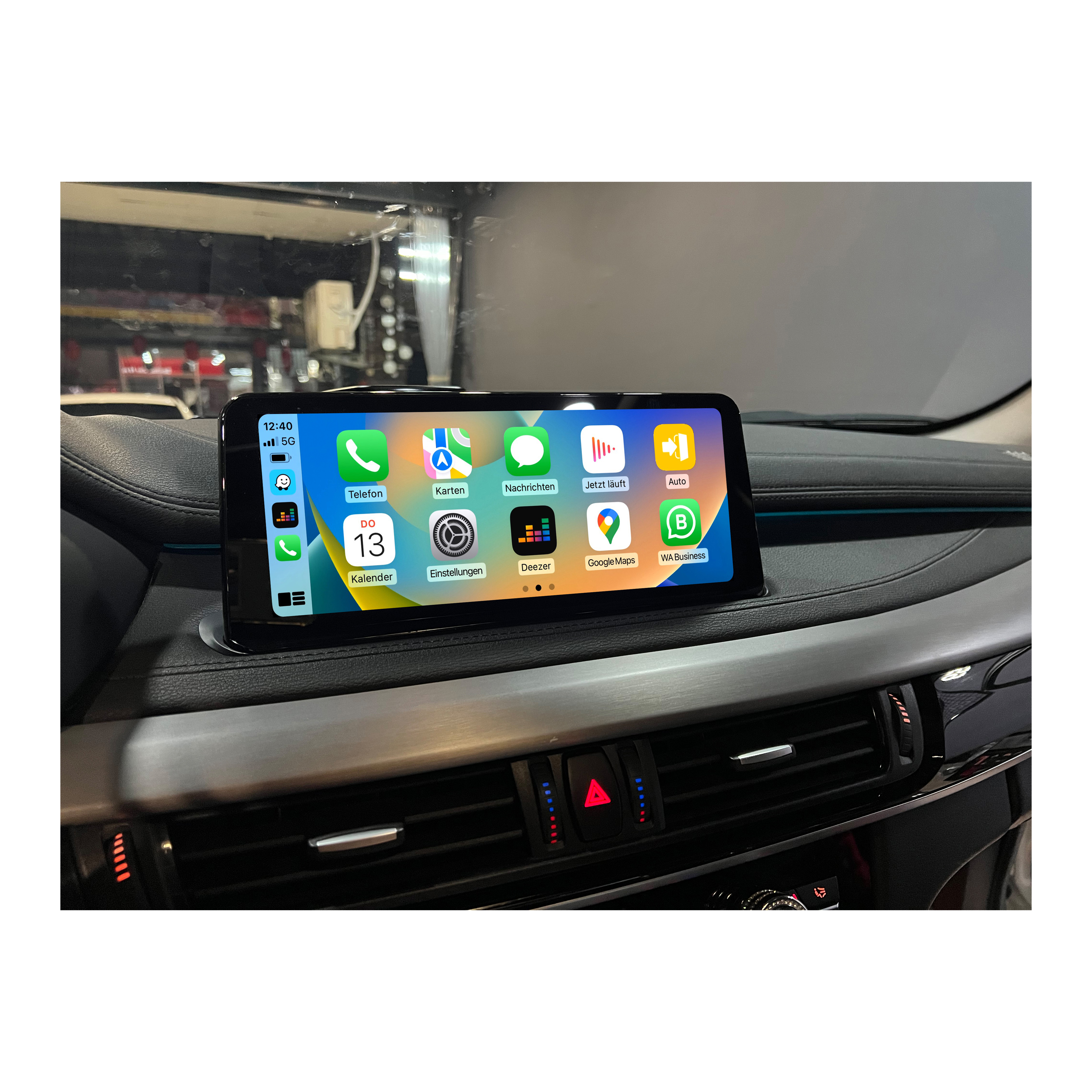 Armaturenbrett eines Autos mit einem Bildschirm mit App-Symbolen, einschließlich Kalender, Karten und Einstellungen.