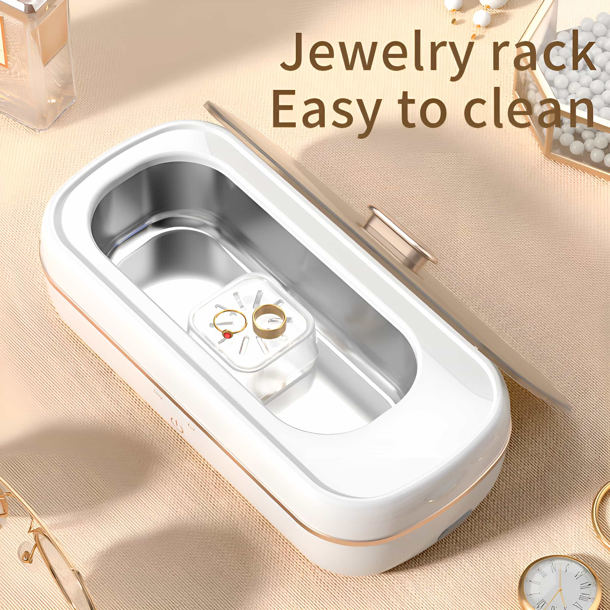 Weißer Schmuckreiniger mit transparentem Deckel. Zwei goldene Ringe sind innen.