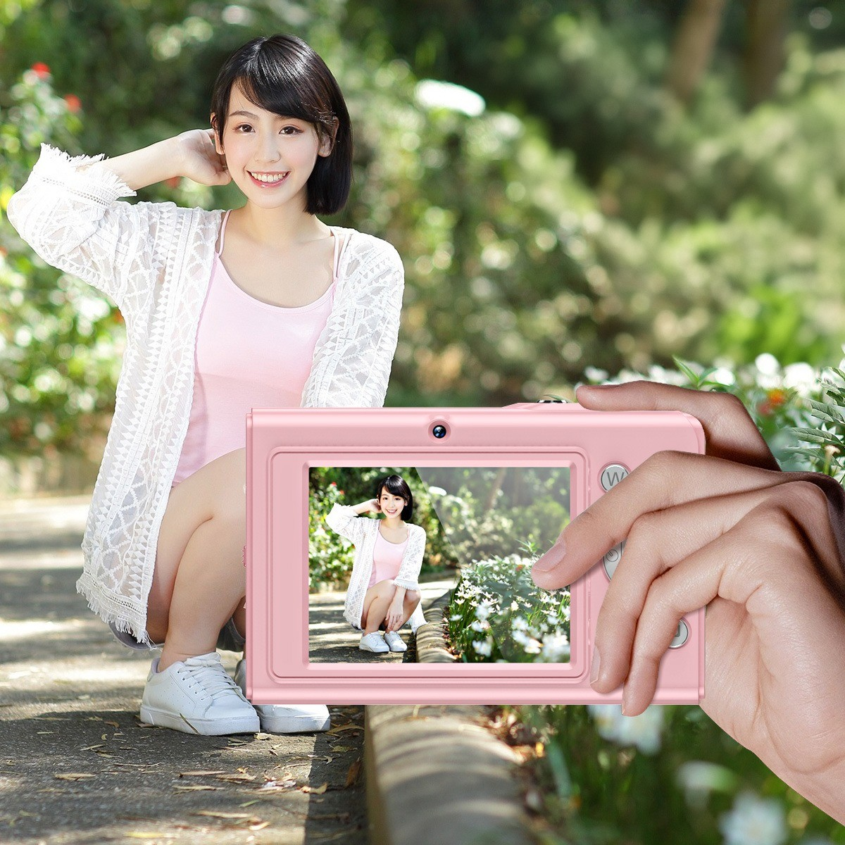 Frau fotografiert mit rosa Kamera. Grüner Hintergrund. Lächelt. Bild.