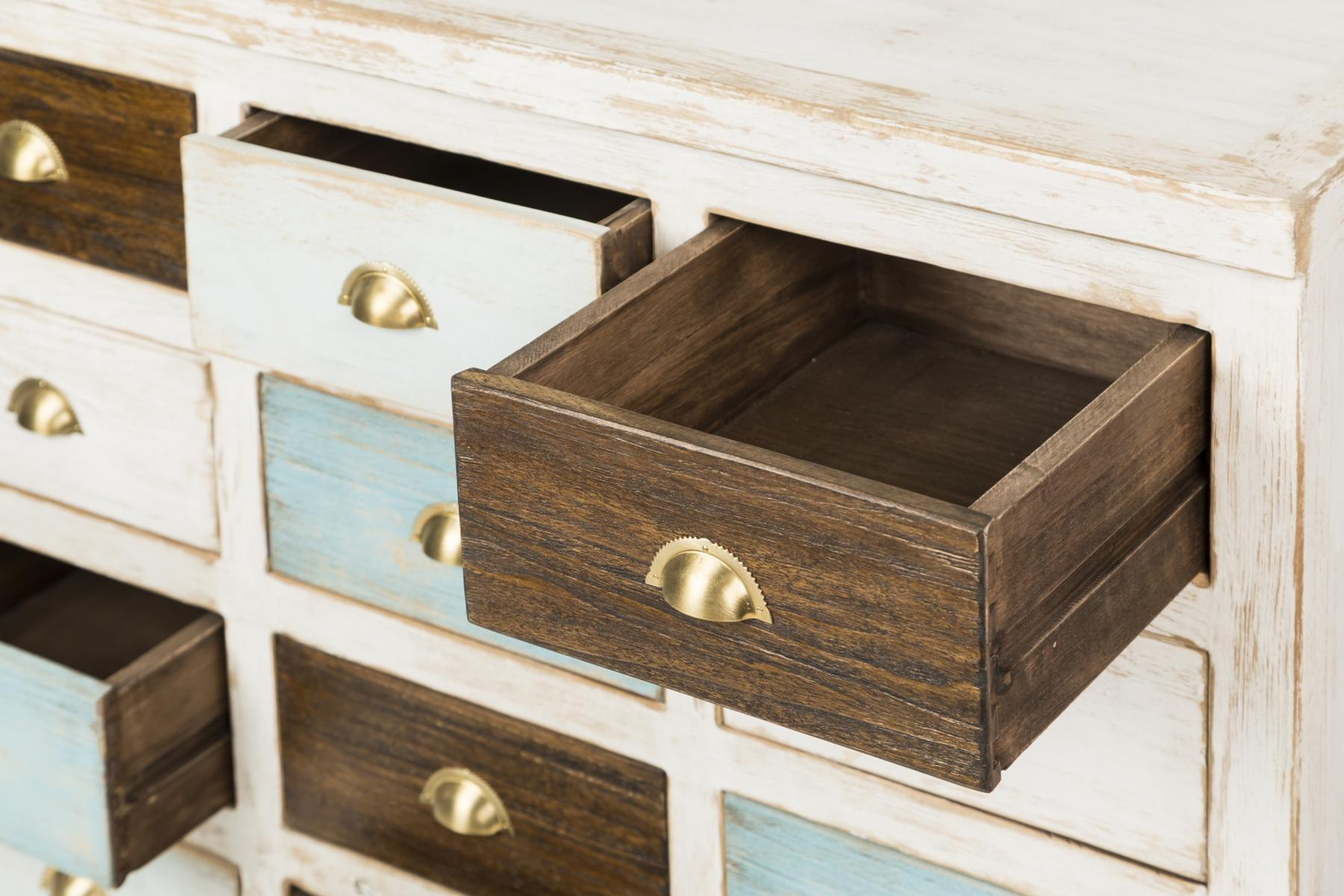 Nahaufnahme eines Holzschranks mit offenen Schubladen. Schubladen haben blaue und braune Farben, goldene Griffe.