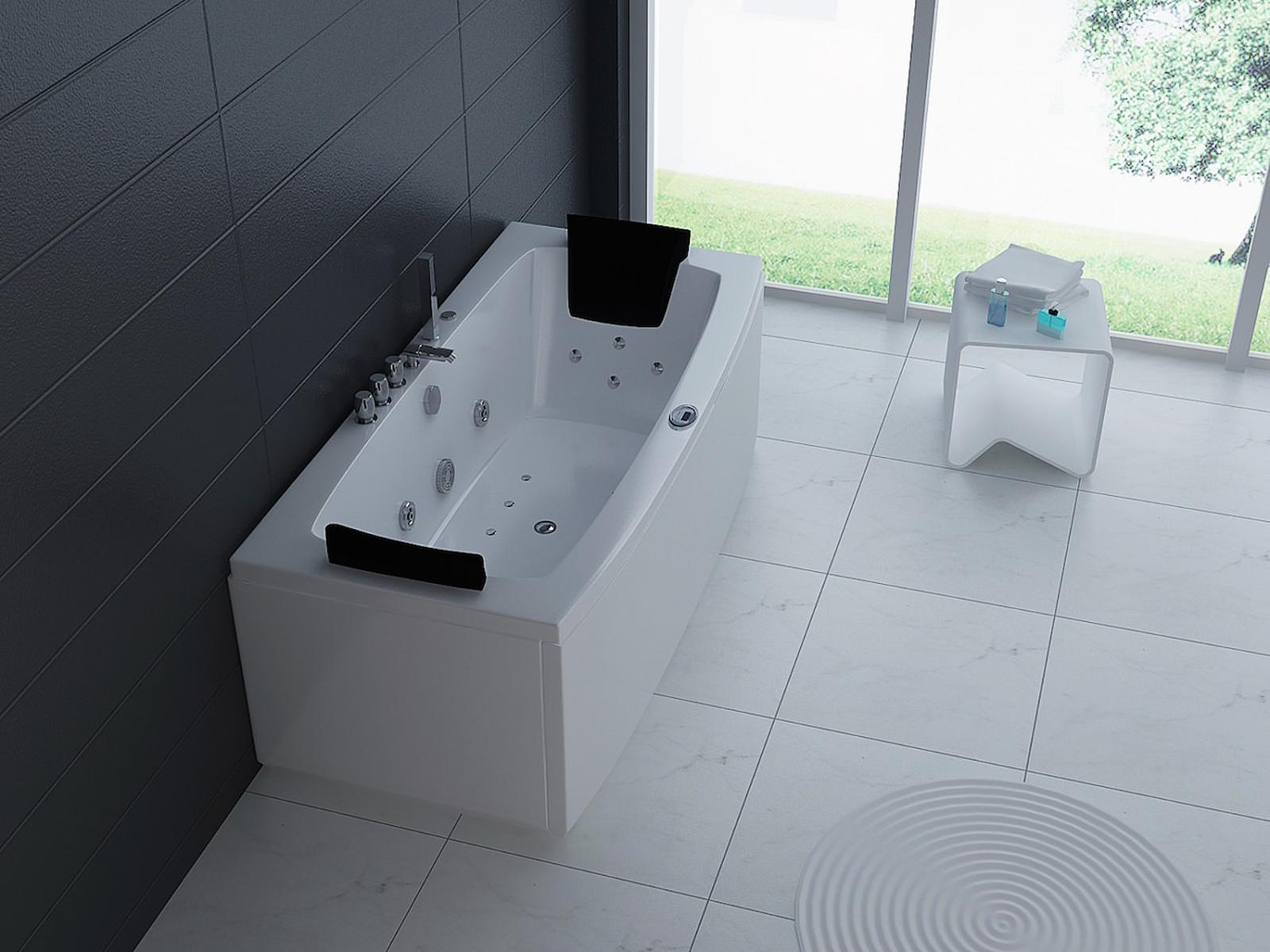 Moderne weiße Badewanne mit schwarzen Kopfstützen in einem Badezimmer mit Fenster und weißen Fliesen.