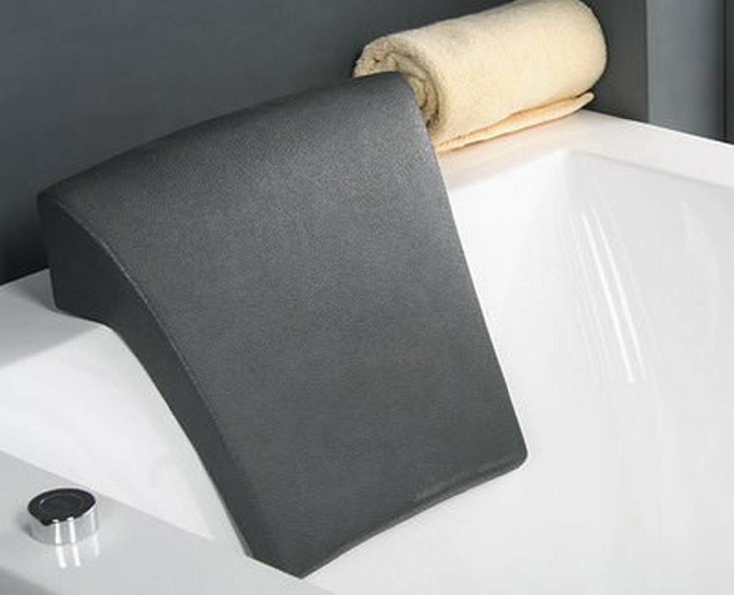 Graues Badkissen auf weißer Wanne. Ein Handtuch liegt am Wannenrand.