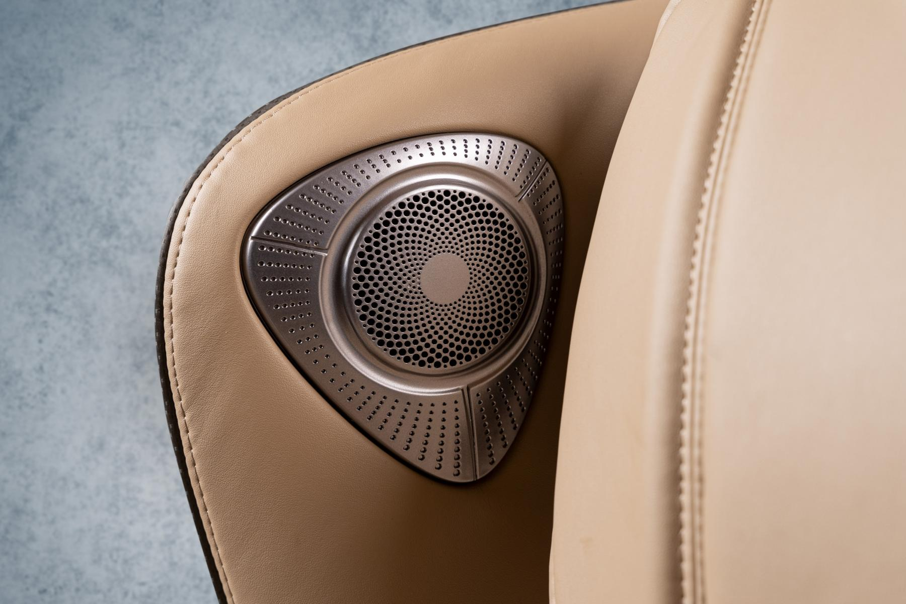 Auto-Lautsprecher. Silber, dreieckige Form. Beiger Lederhintergrund.