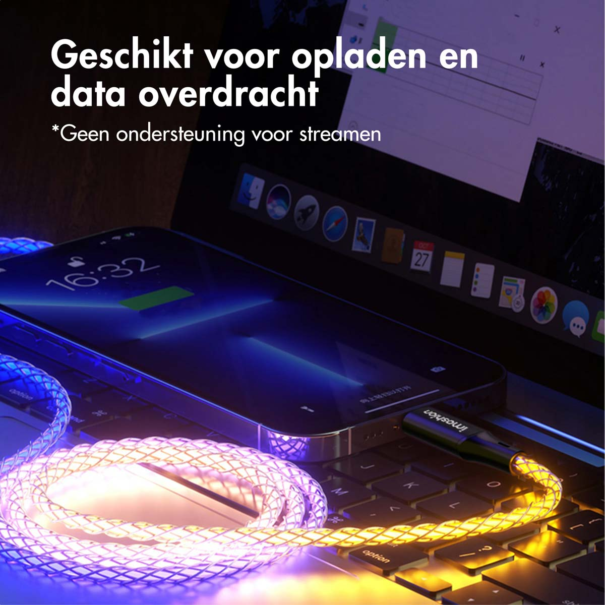 Téléphone et ordinateur portable avec câble en charge. Le téléphone se charge. Effets de lumière bleue et violette sur le câble.