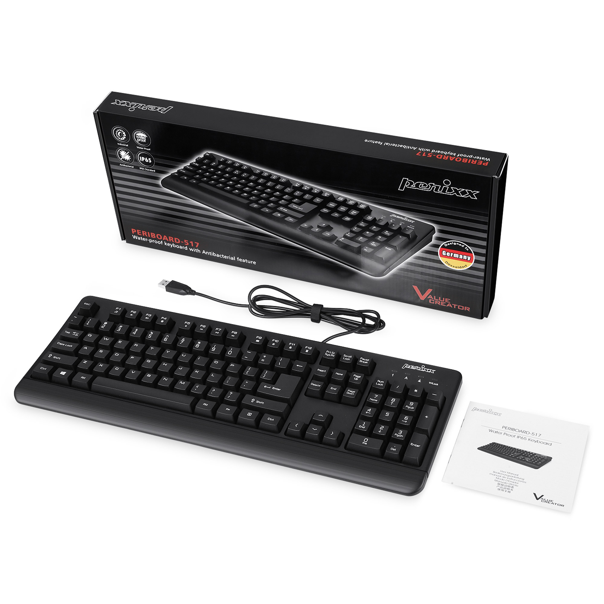 Eine schwarze Tastatur mit einer Box und einem Handbuch auf weißem Hintergrund.