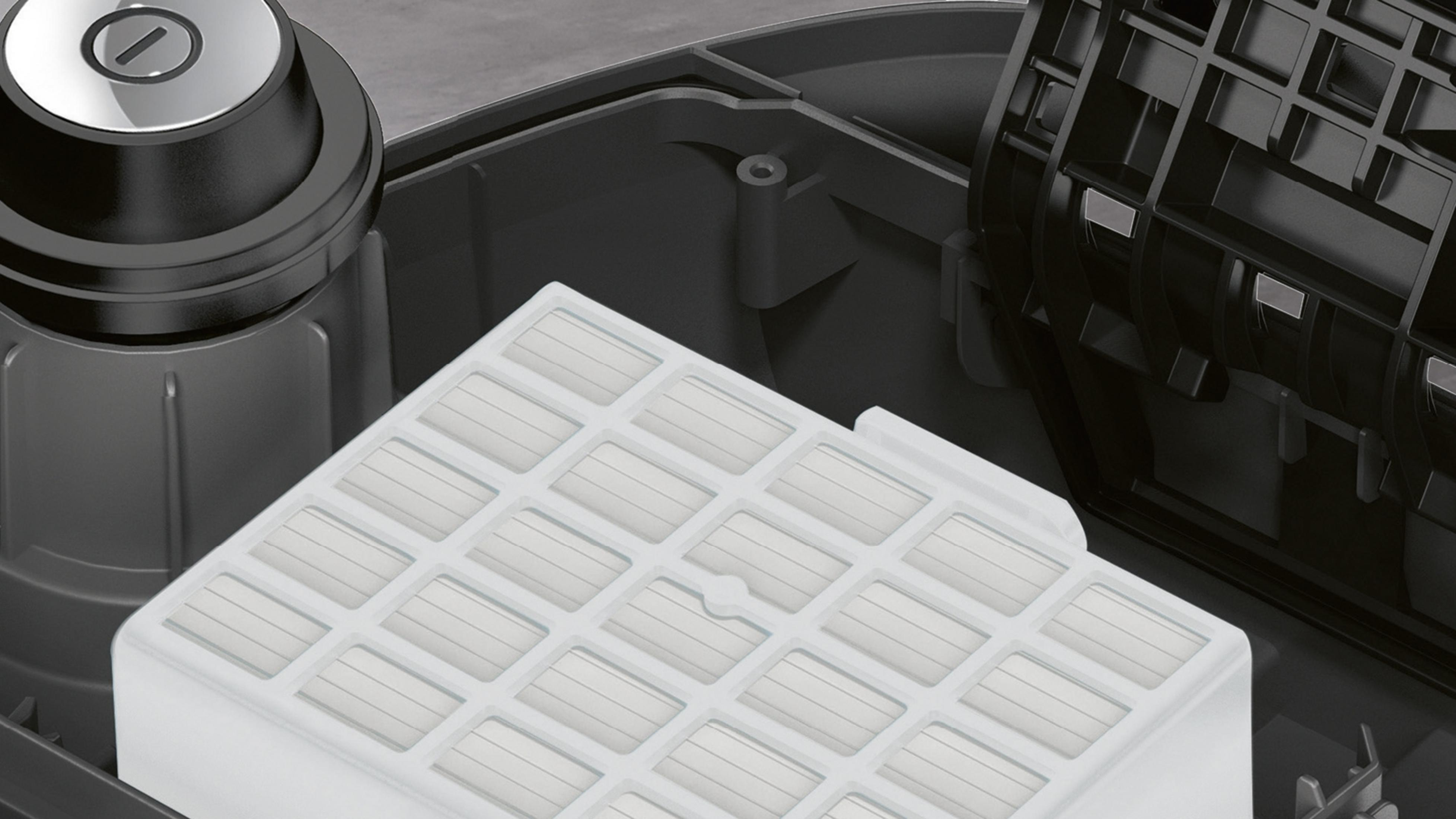 Zbliżenie białego filtra powietrza wewnątrz ciemnoszarego odkurzacza.