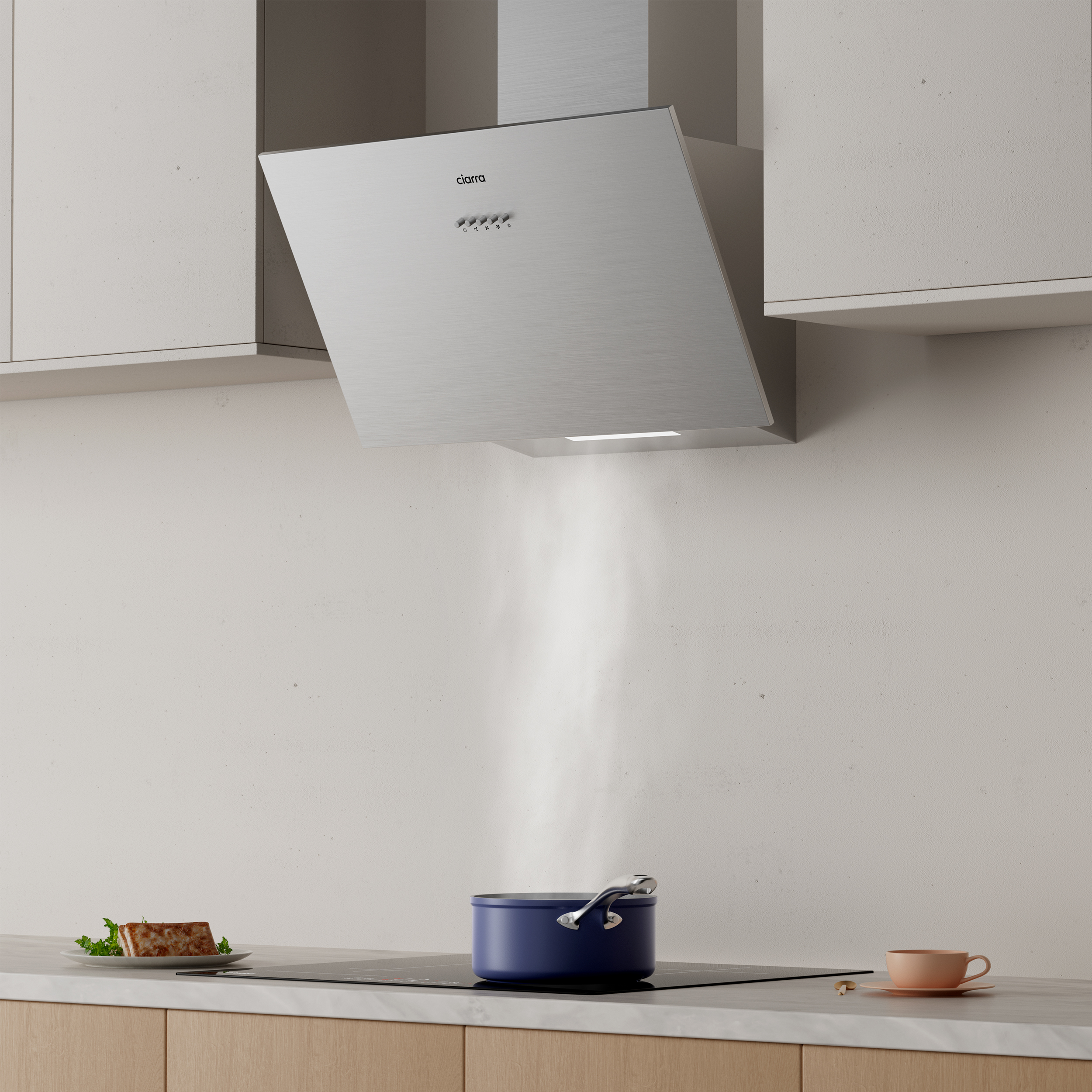 A modern stainless steel range hood over a blue pot on a black stovetop in a kitchen.
