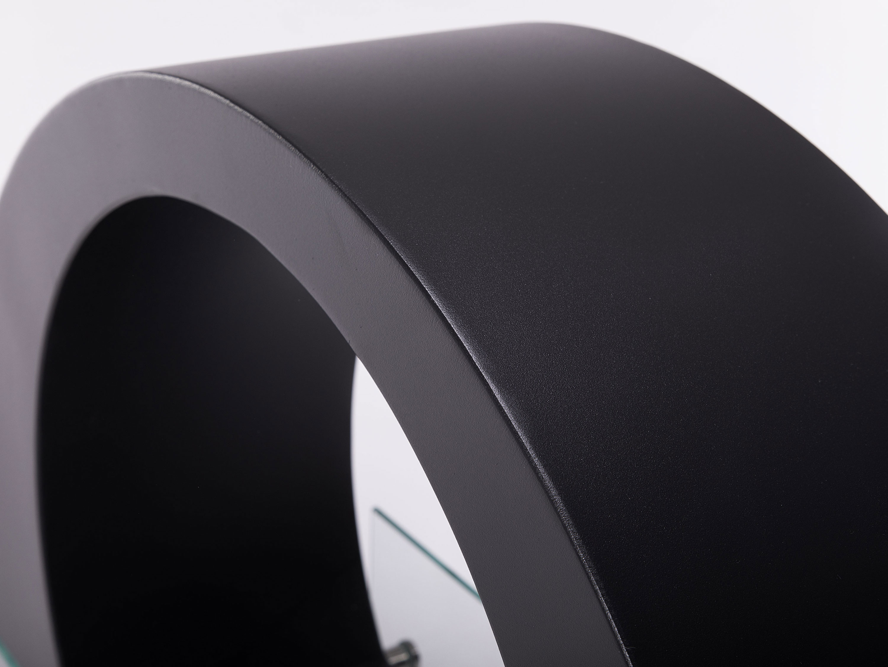 Un objeto negro en forma de arco con un diseño curvo. El objeto tiene una superficie brillante.