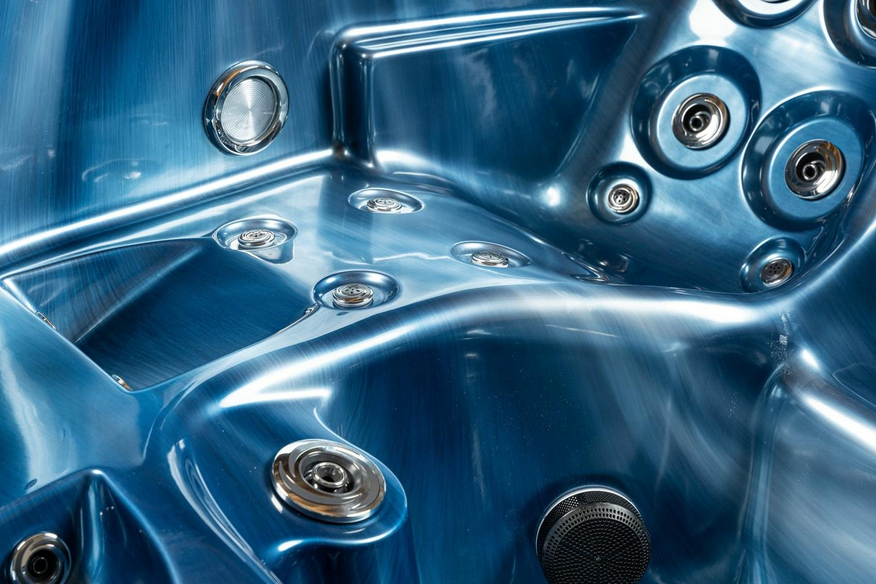 Ein blaues und glänzendes Whirlpool-Interieur mit Düsen und metallischen Akzenten.