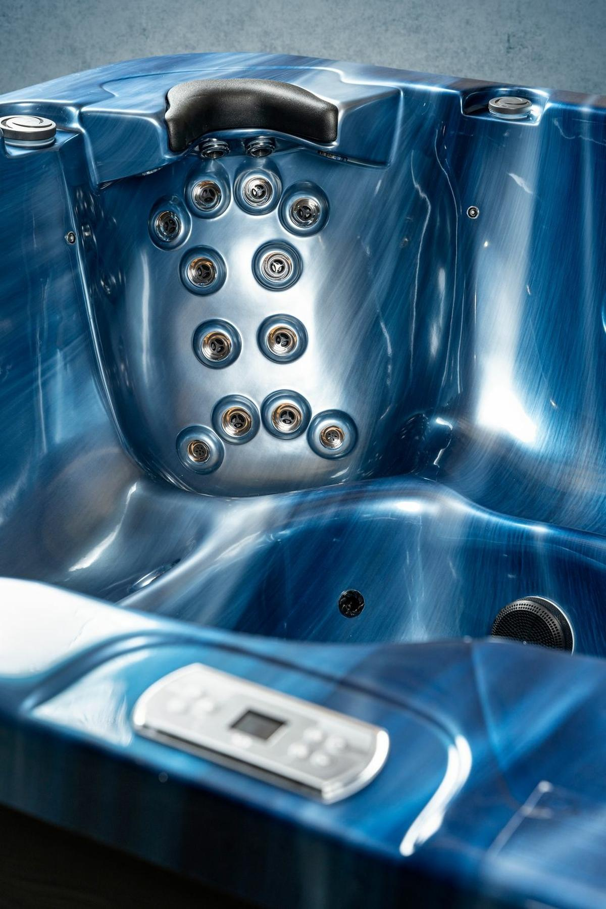 Nahaufnahme eines blauen Whirlpool-Innenraums mit Düsen und Bedienfeld. Es hat ein Metallic-Finish.