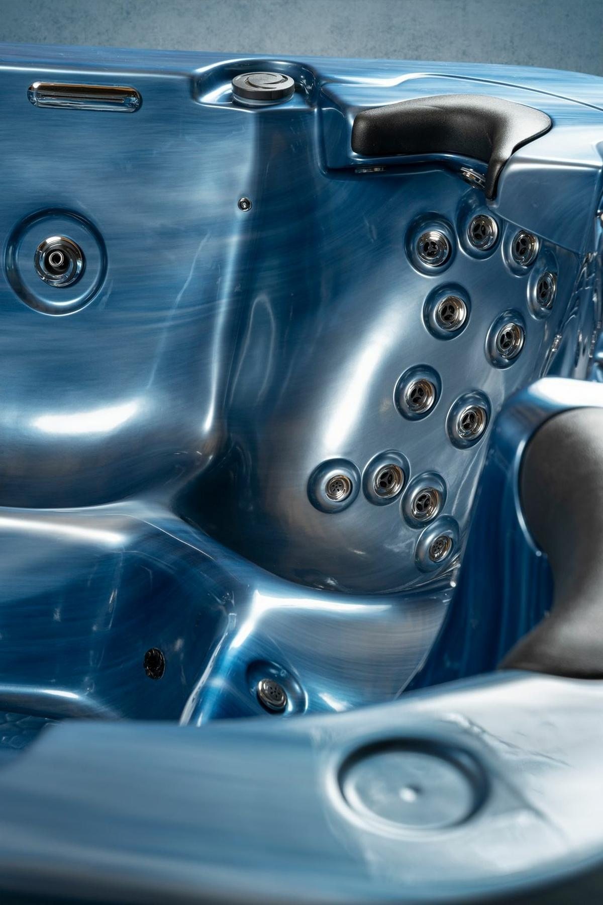 Ein blaues Spa mit mehreren Wasserdüsen. Das Spa hat ein metallisches Finish.
