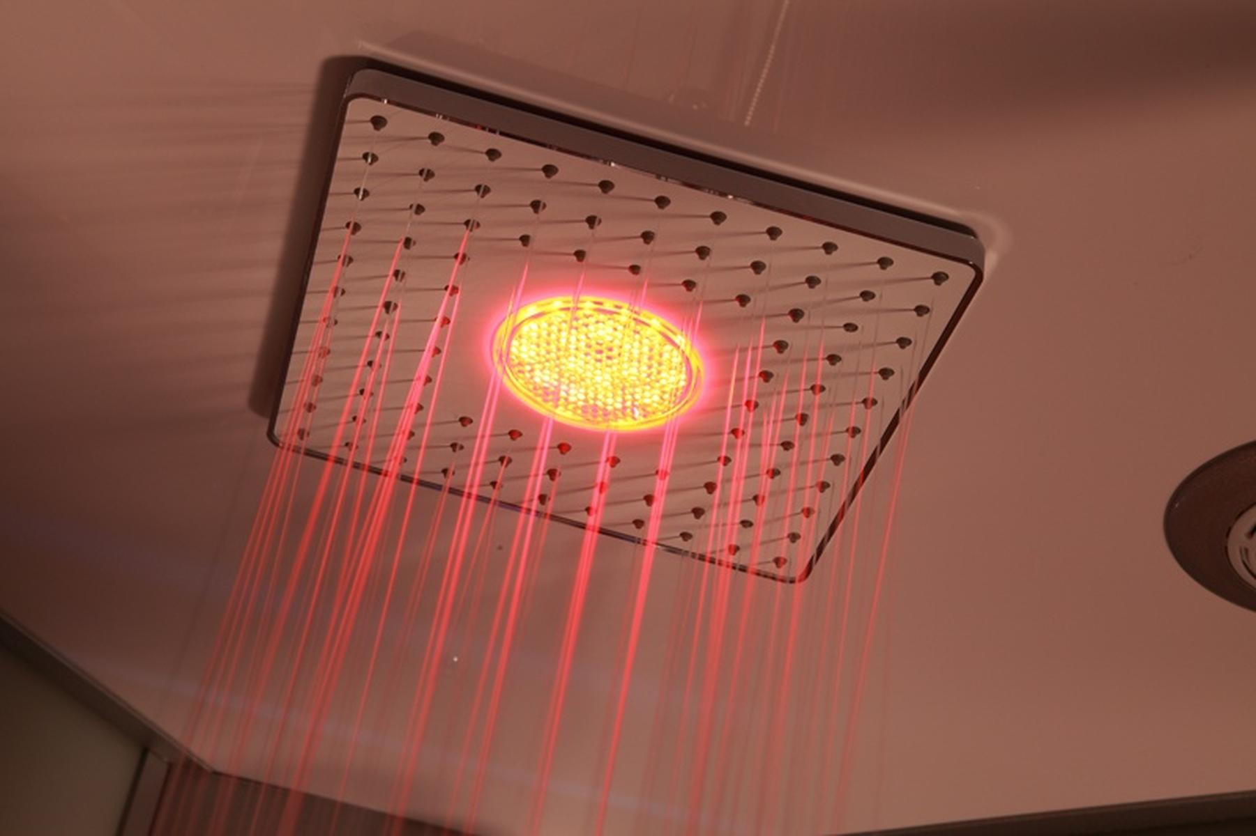 Quadratischer Duschkopf mit rotem Licht. Es hat mehrere Düsen.
