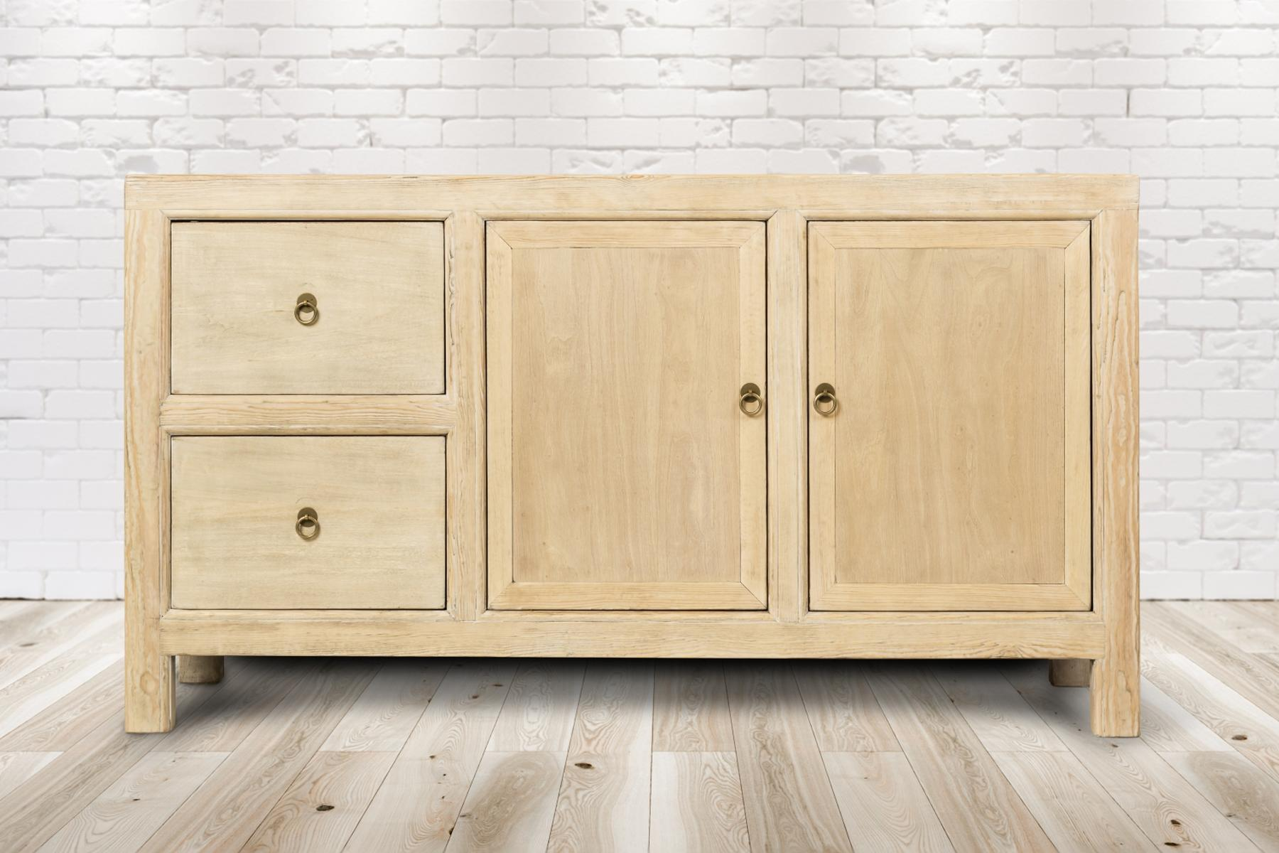 Holzschrank mit Schubladen und Türen vor einer Backsteinmauer.