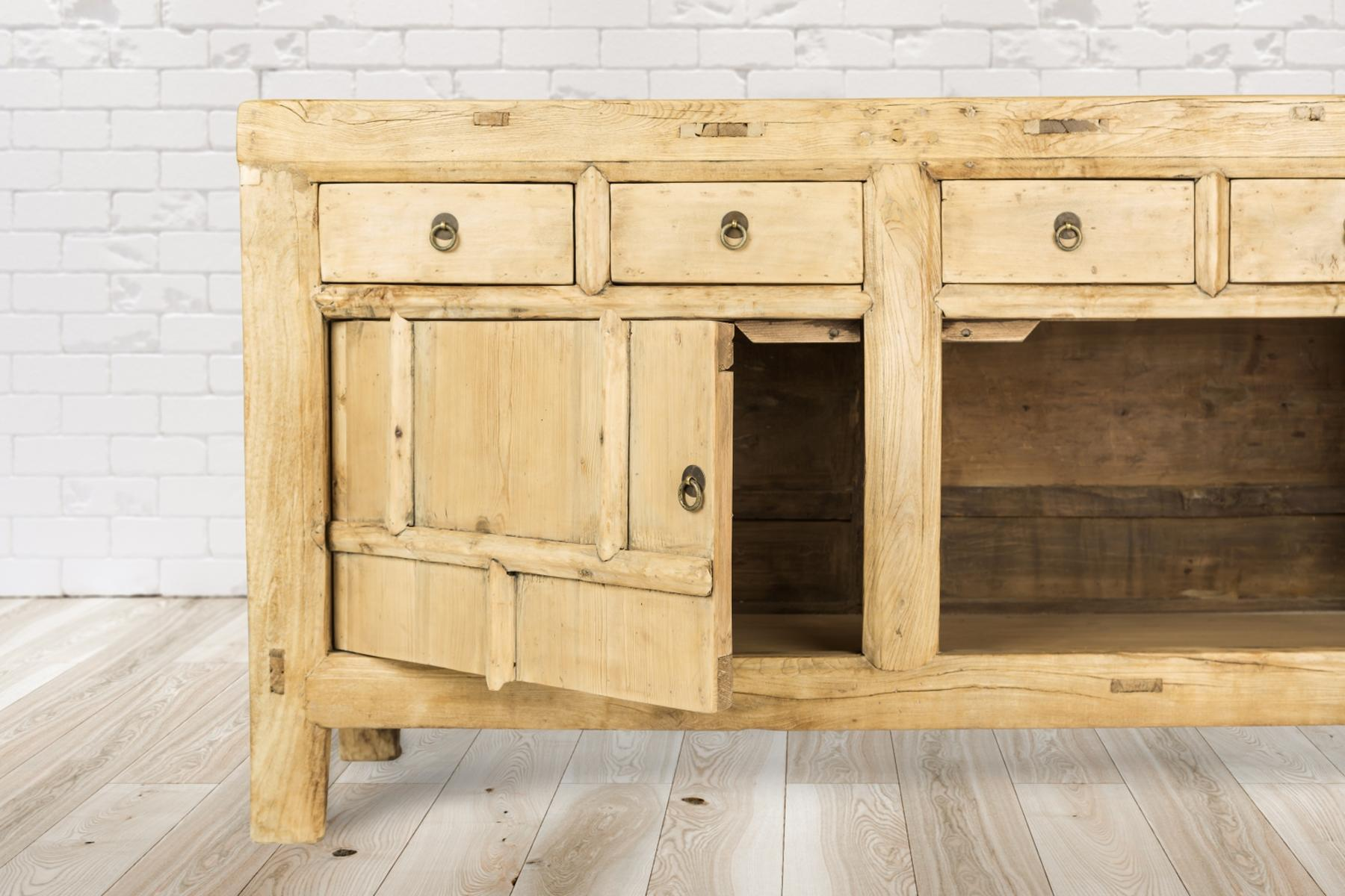 Holzschrank mit Schubladen und offener Tür, auf Holzfußboden.