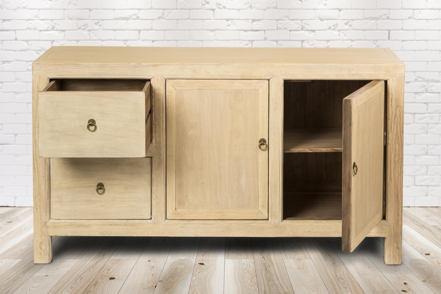 Ein Holzschrank mit Schubladen und Türen vor einer weißen Backsteinmauer.